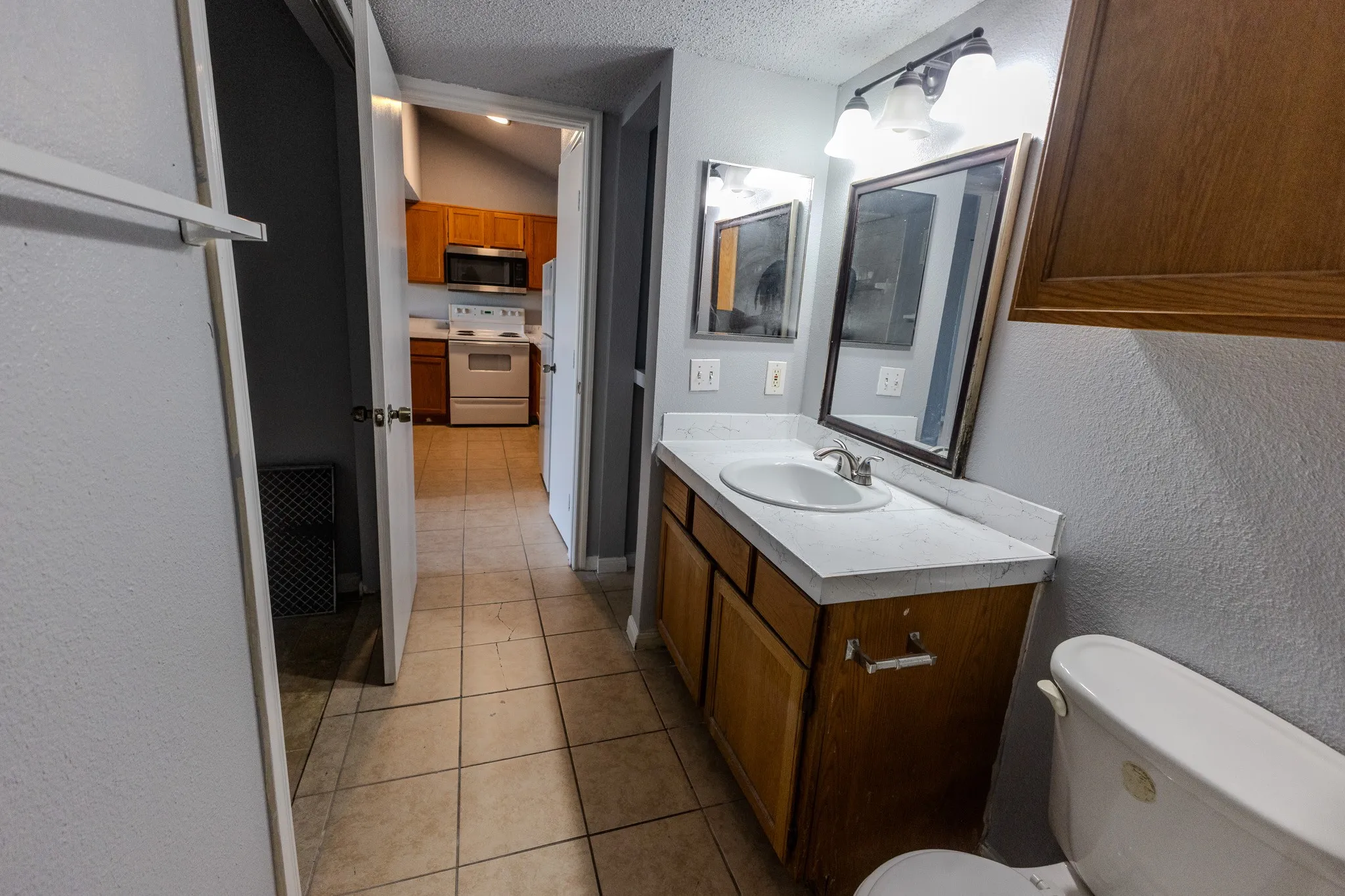 Vanity with an integrated sink, framed mirror, and wood-finish cabinetry