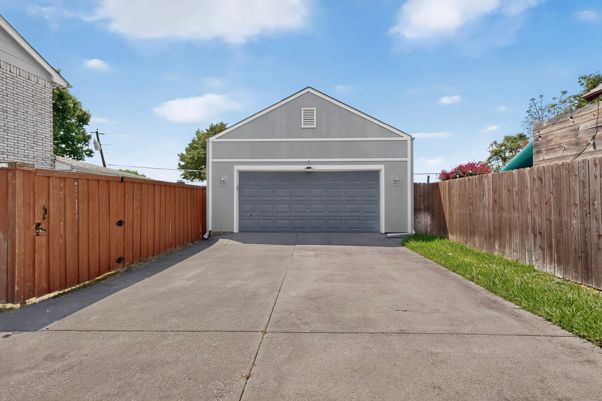 Detached garage with a paneled door and gabled roofline