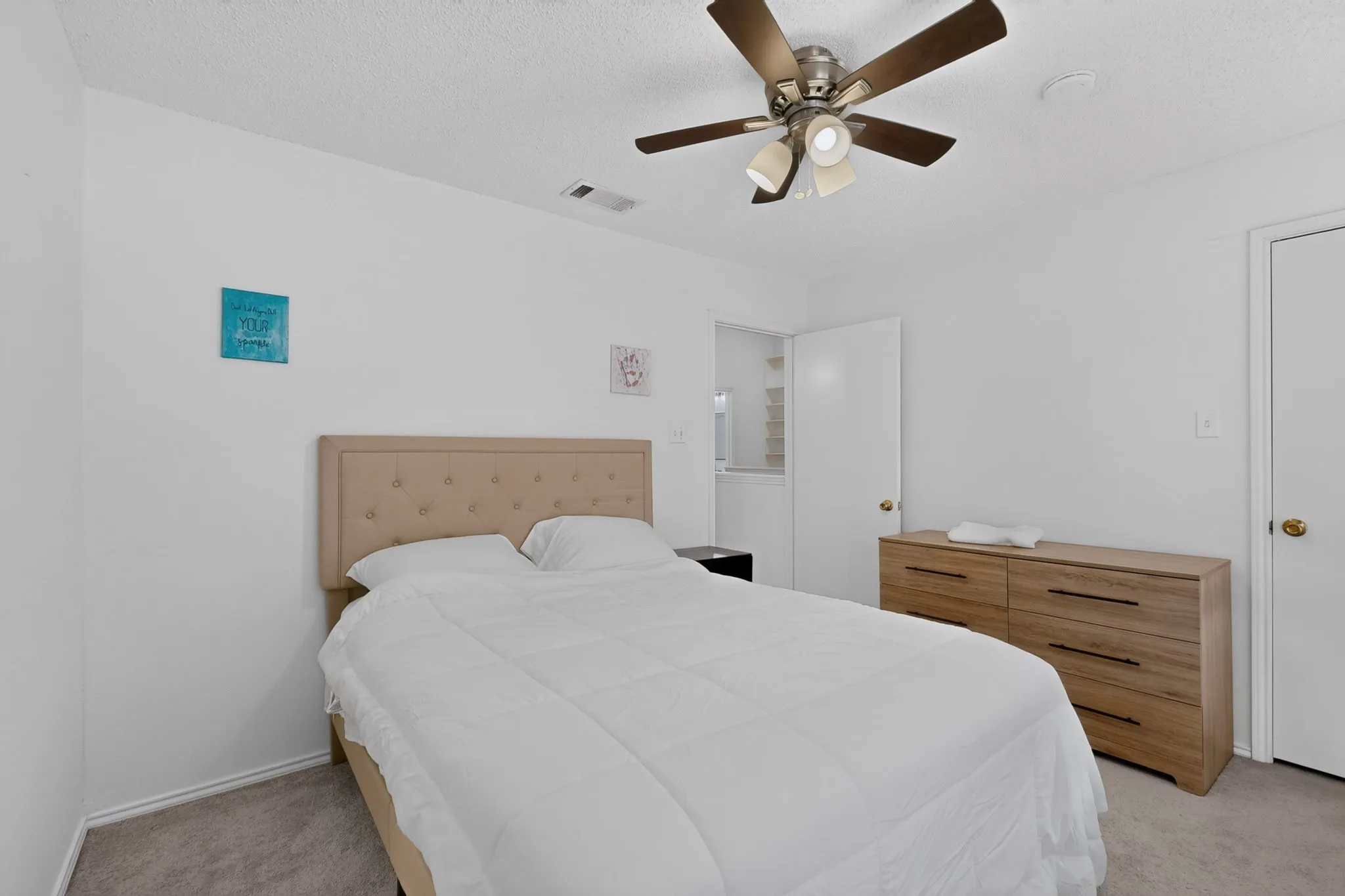Carpeted flooring, white walls, and a ceiling fan with integrated lighting