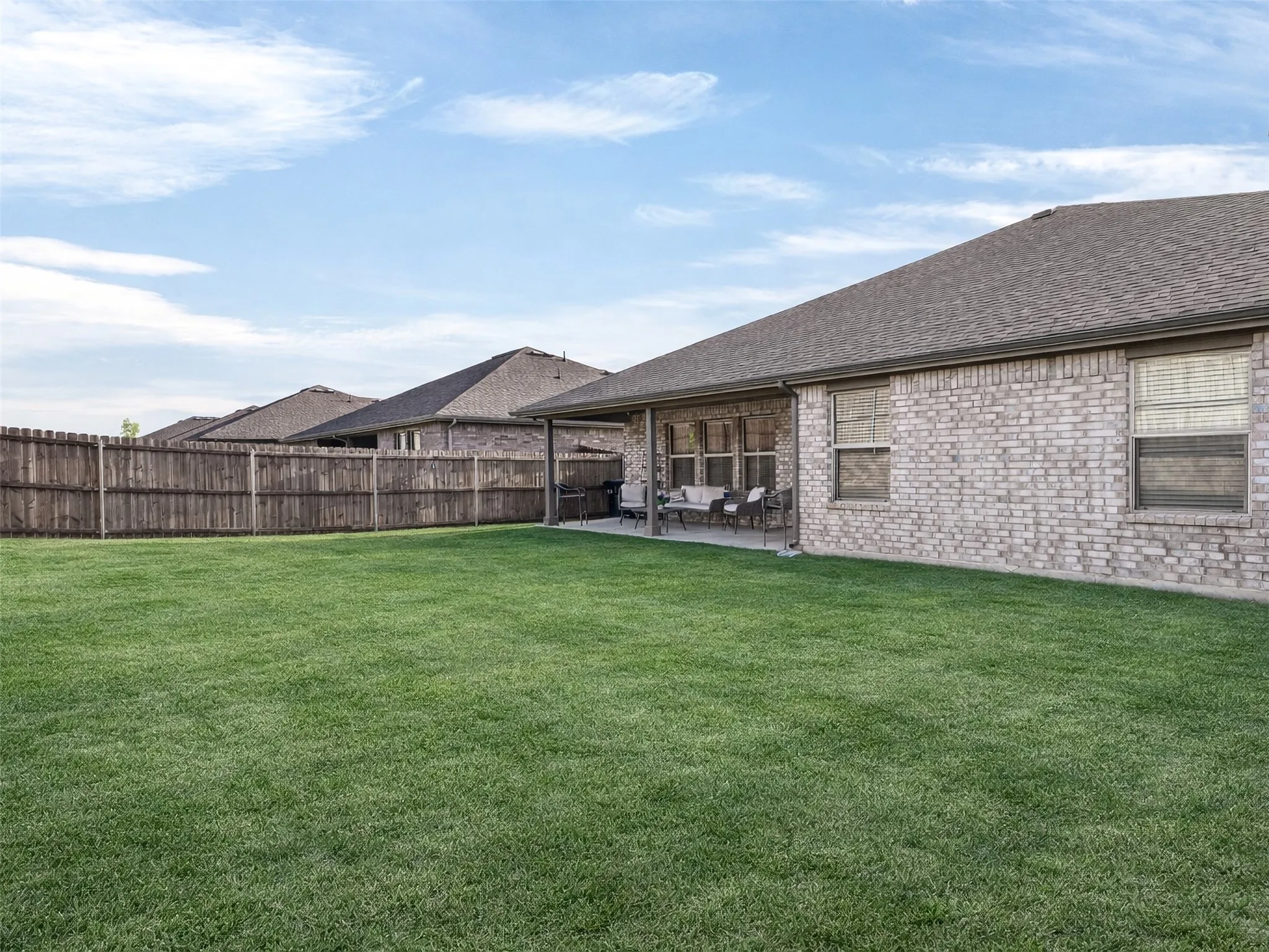 Expansive grass yard with a full privacy fence