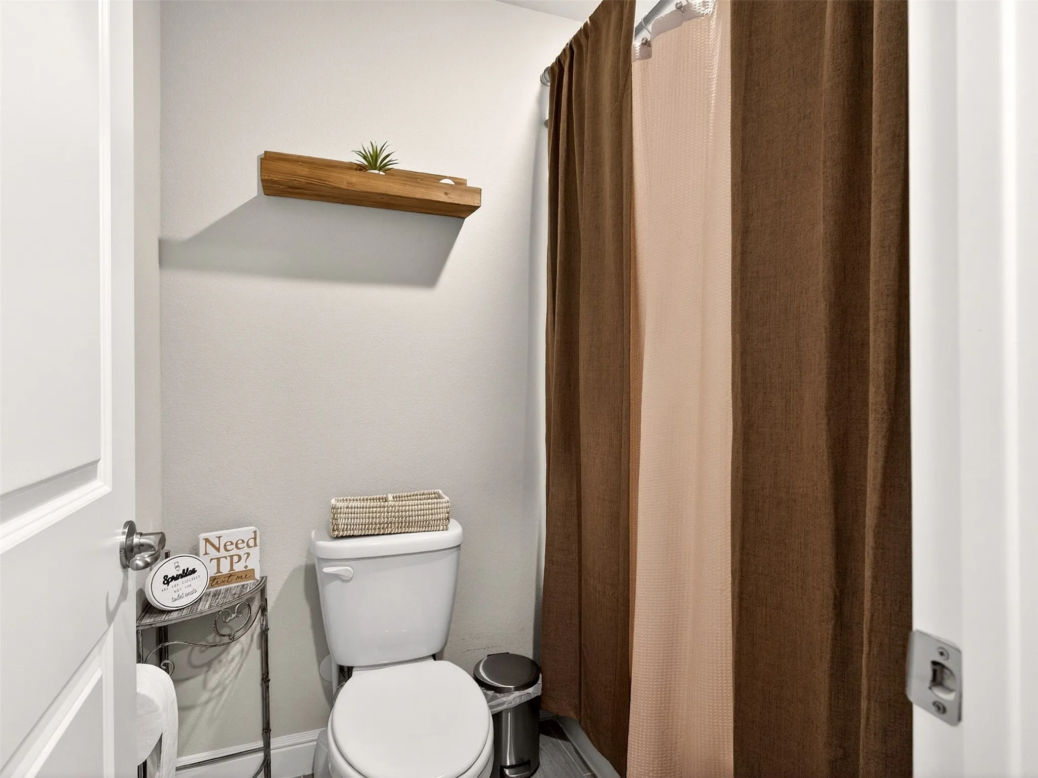 White toilet and a shower area with a two-tone shower curtain