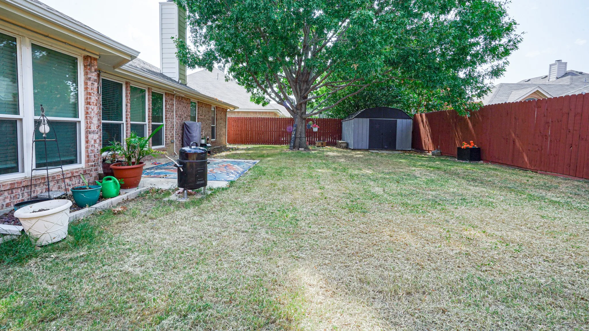 Fenced yard with storage unit and patio