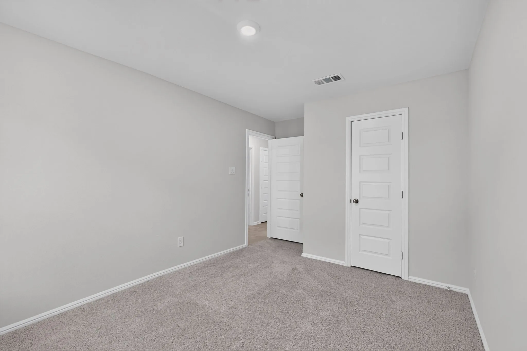 Recessed ceiling lighting, light gray wall paint, gray carpet flooring, white trim, and white five-panel interior doors