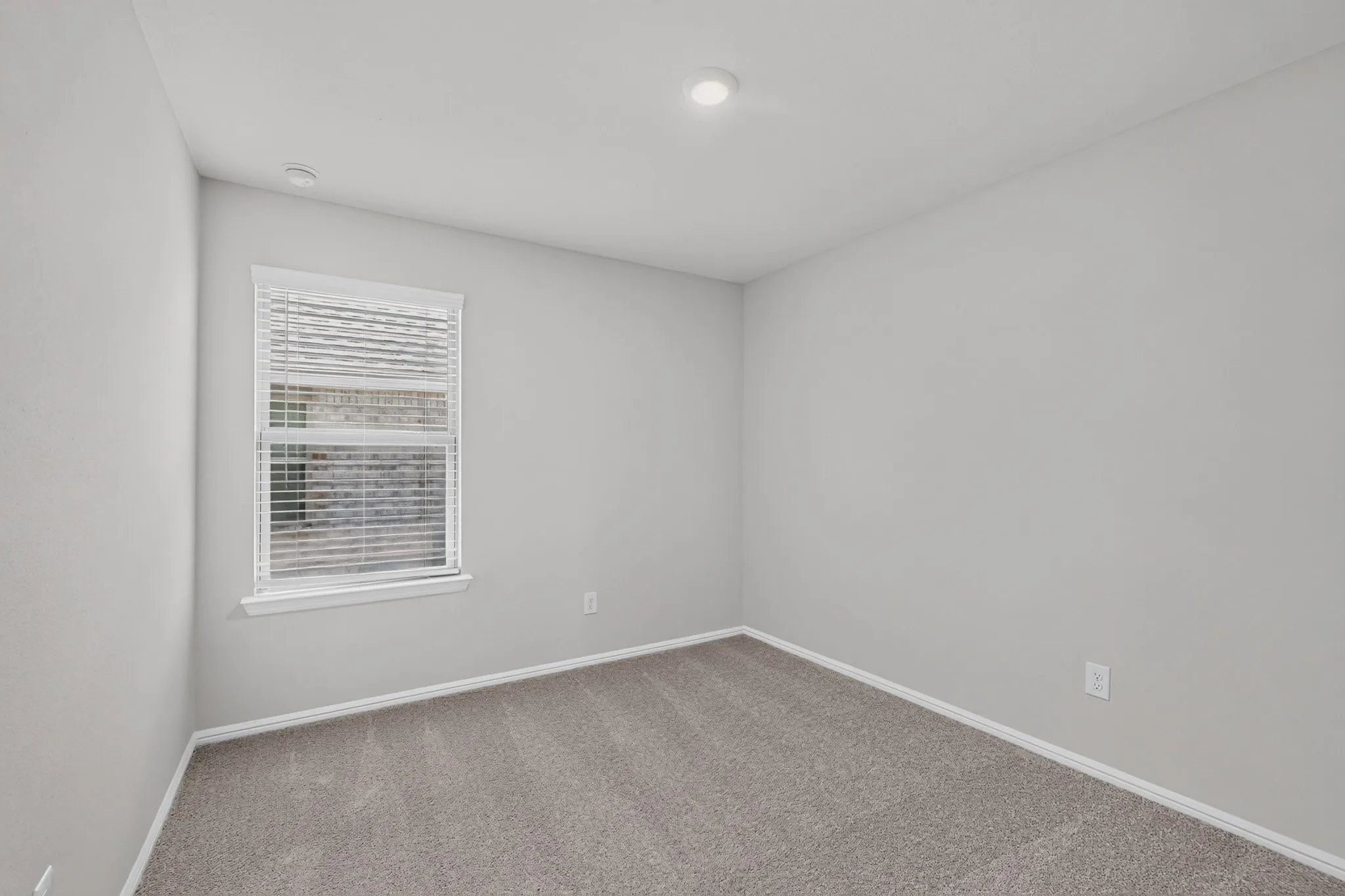 Neutral wall paint, recessed lighting, window with blinds, and carpeting