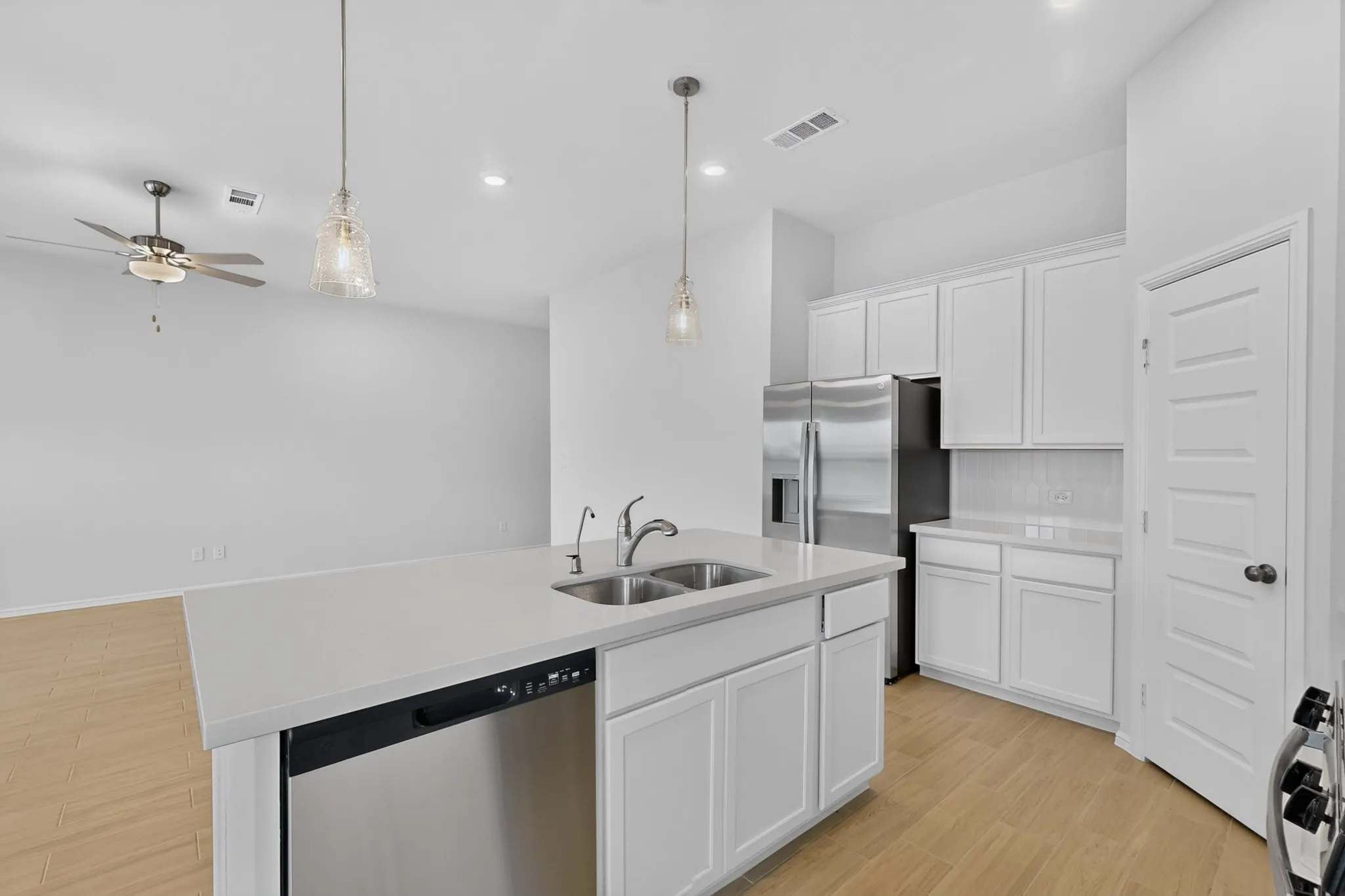 Kitchen island featuring a dual basin sink and integrated dishwasher