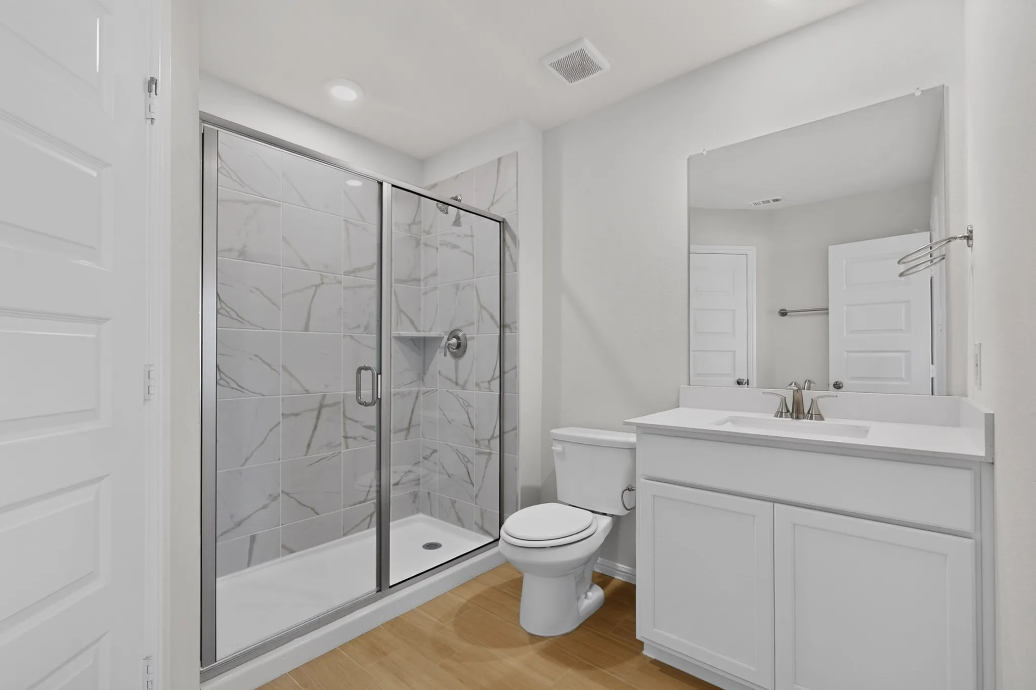 Walk-in shower with clear glass enclosure and tiled walls