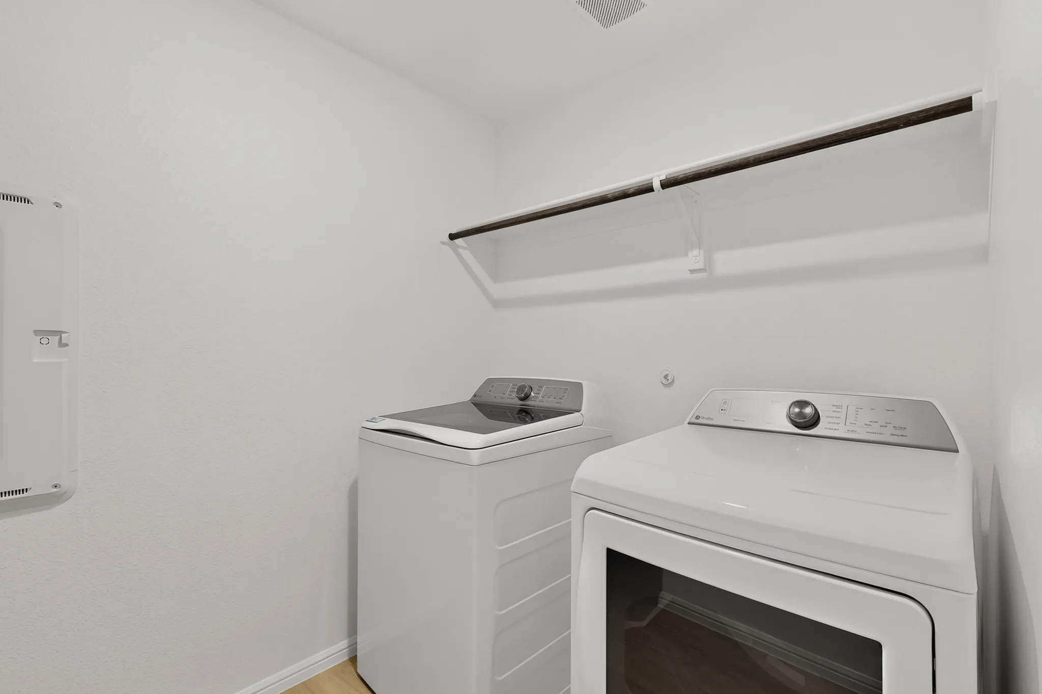White walls with baseboard trim, and wood-finish flooring