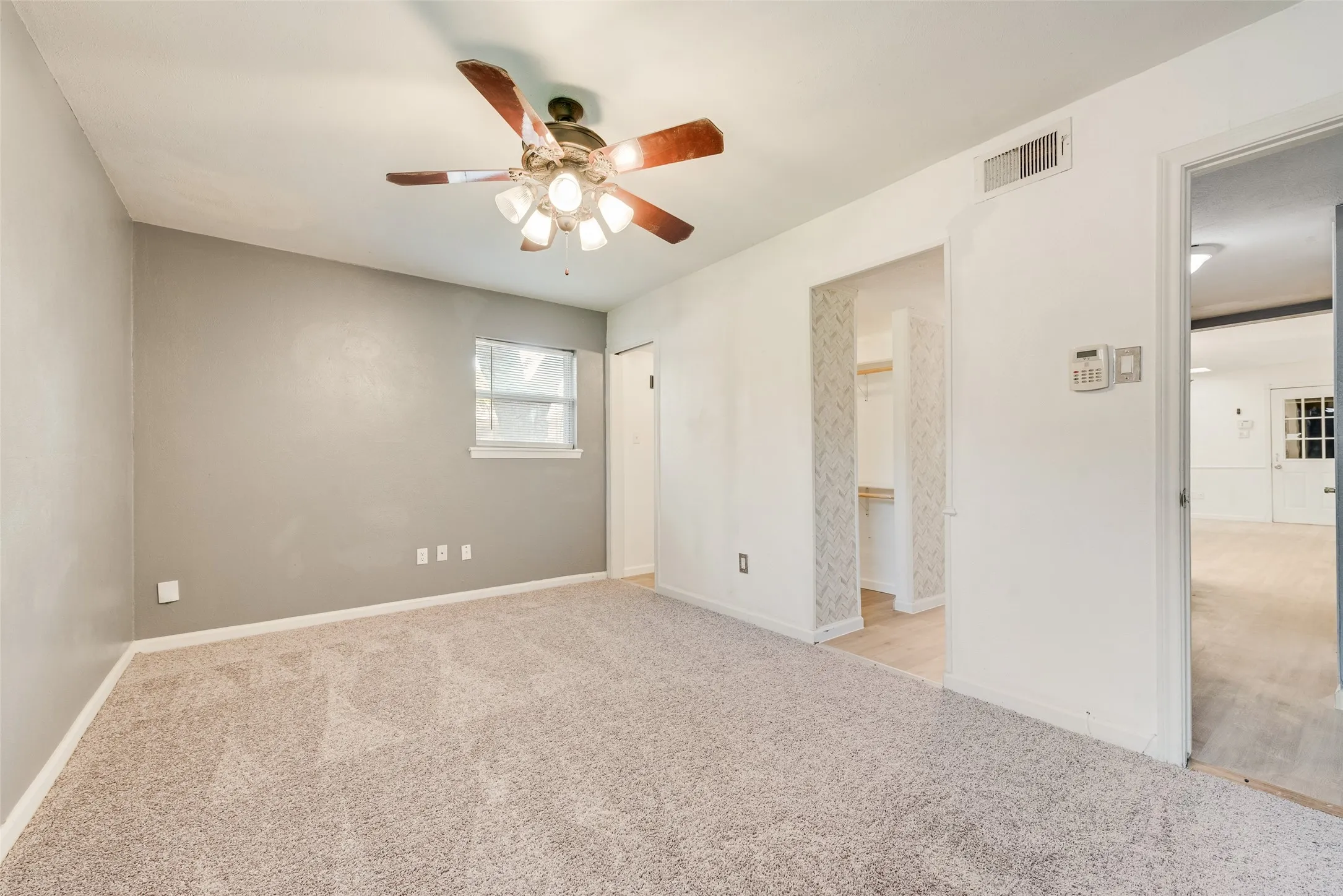 Recessed window, ceiling fan with integrated lighting, carpet flooring, and an open closet with shelving