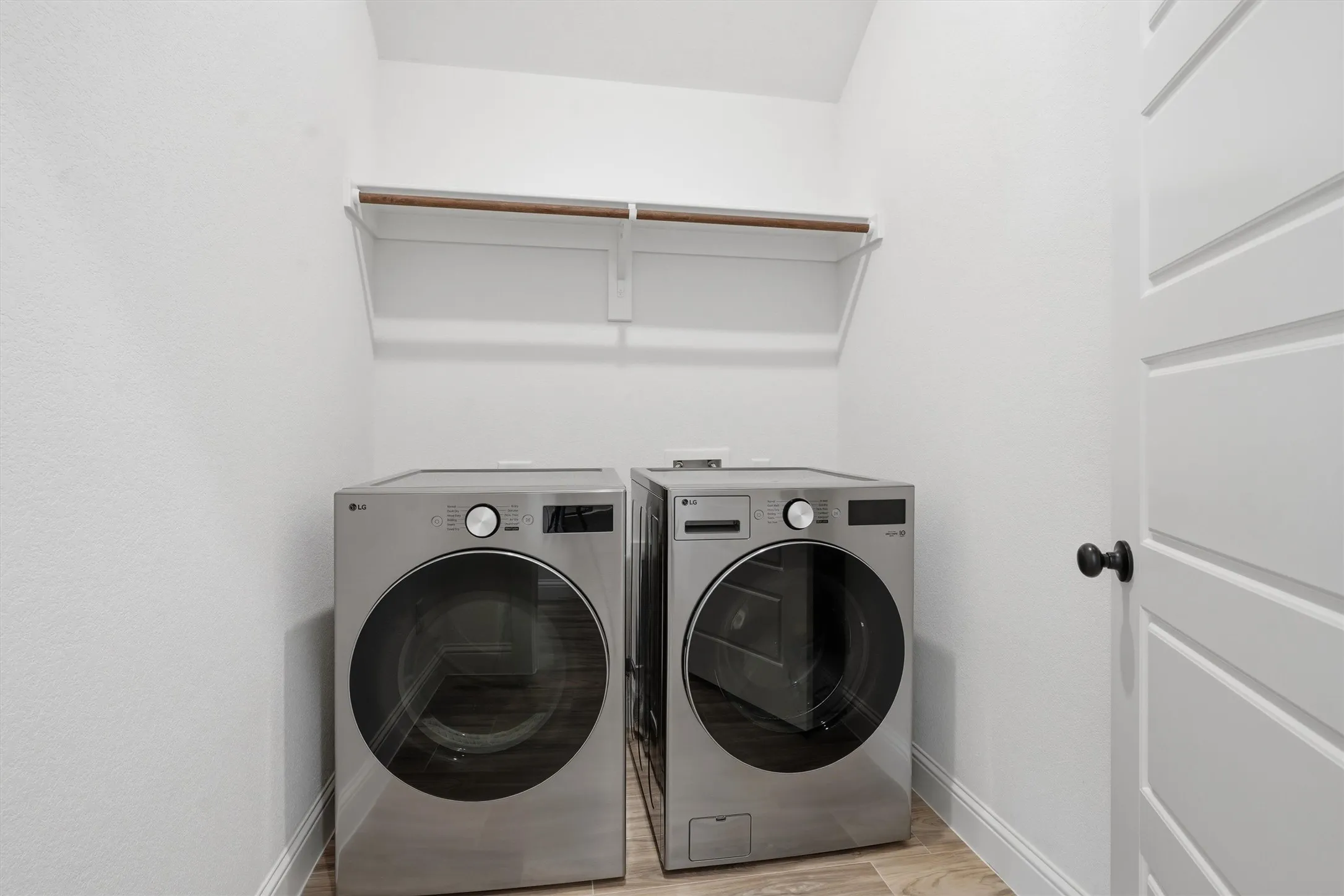Dedicated laundry area featuring a built-in shelf and hanging rod
