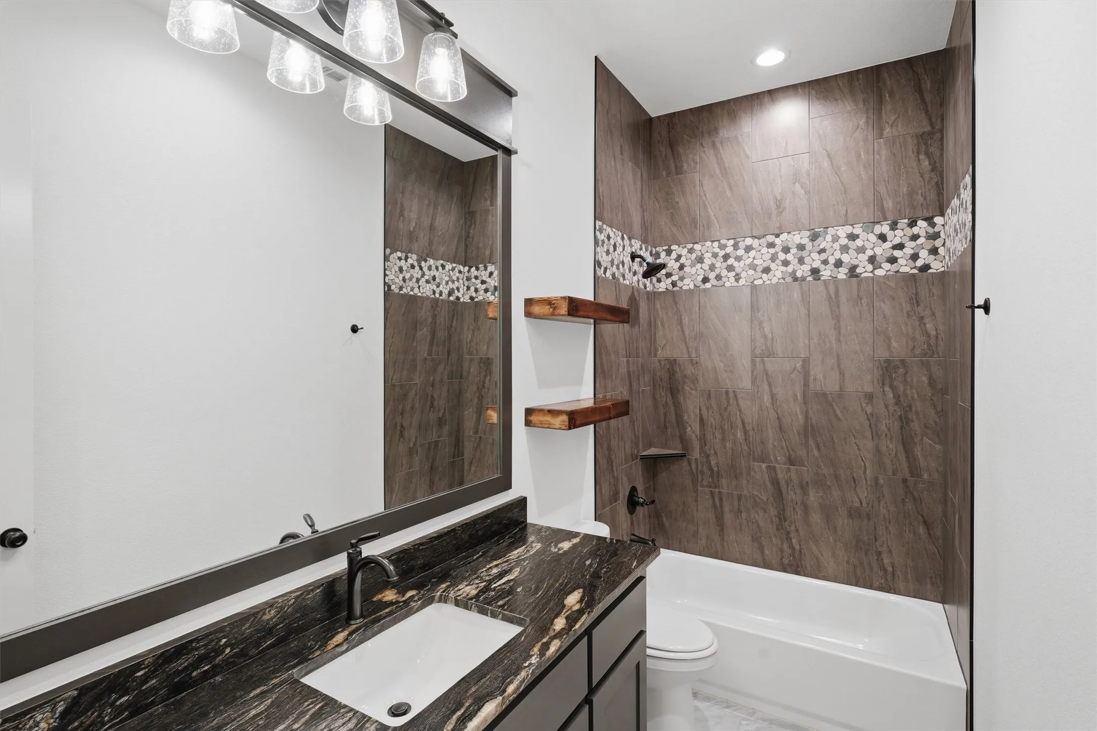 Vanity with stone countertop, undermount sink, and dark-finish faucet