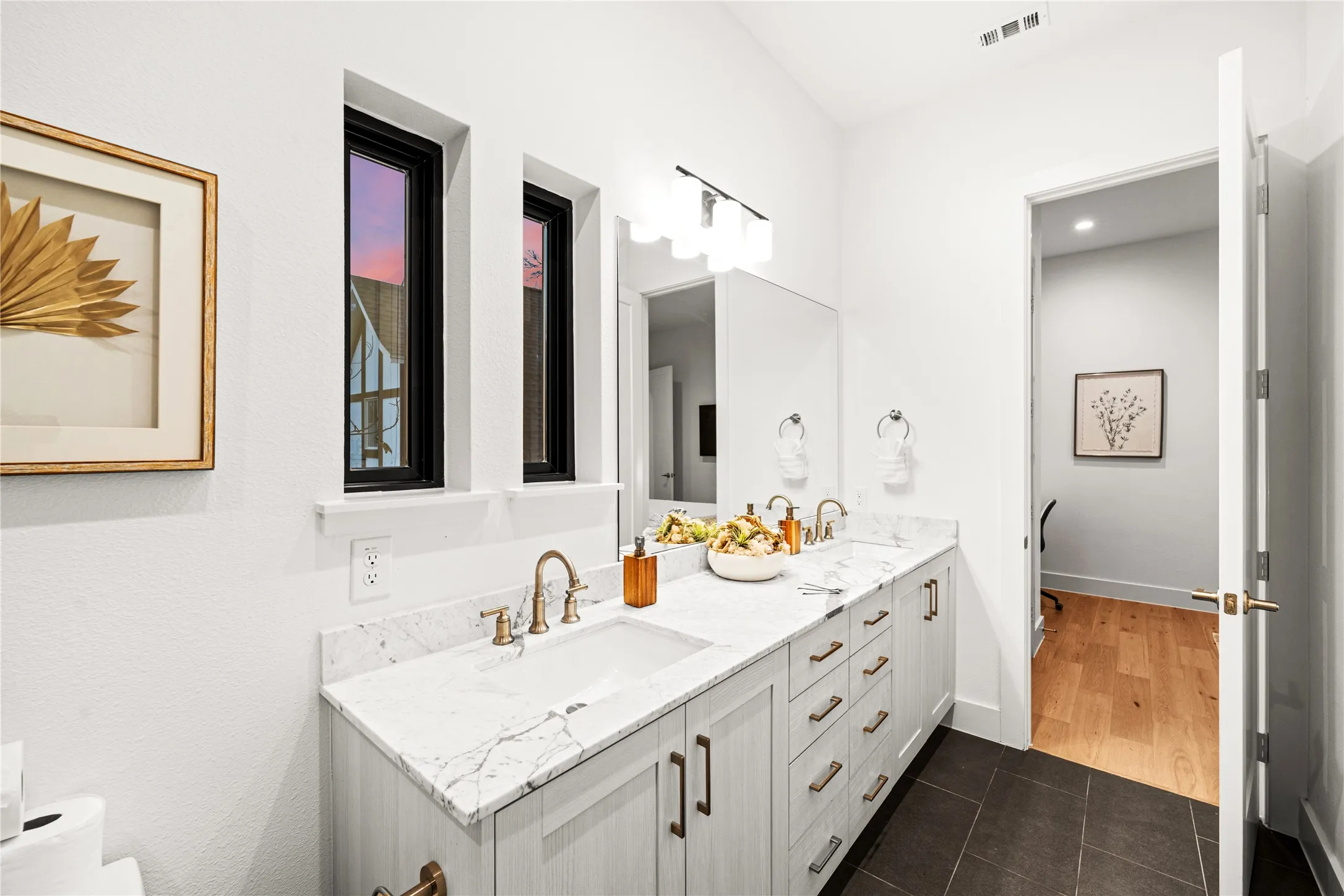 Dual vanity with white countertop, undermount sinks, and brass-finish fixtures