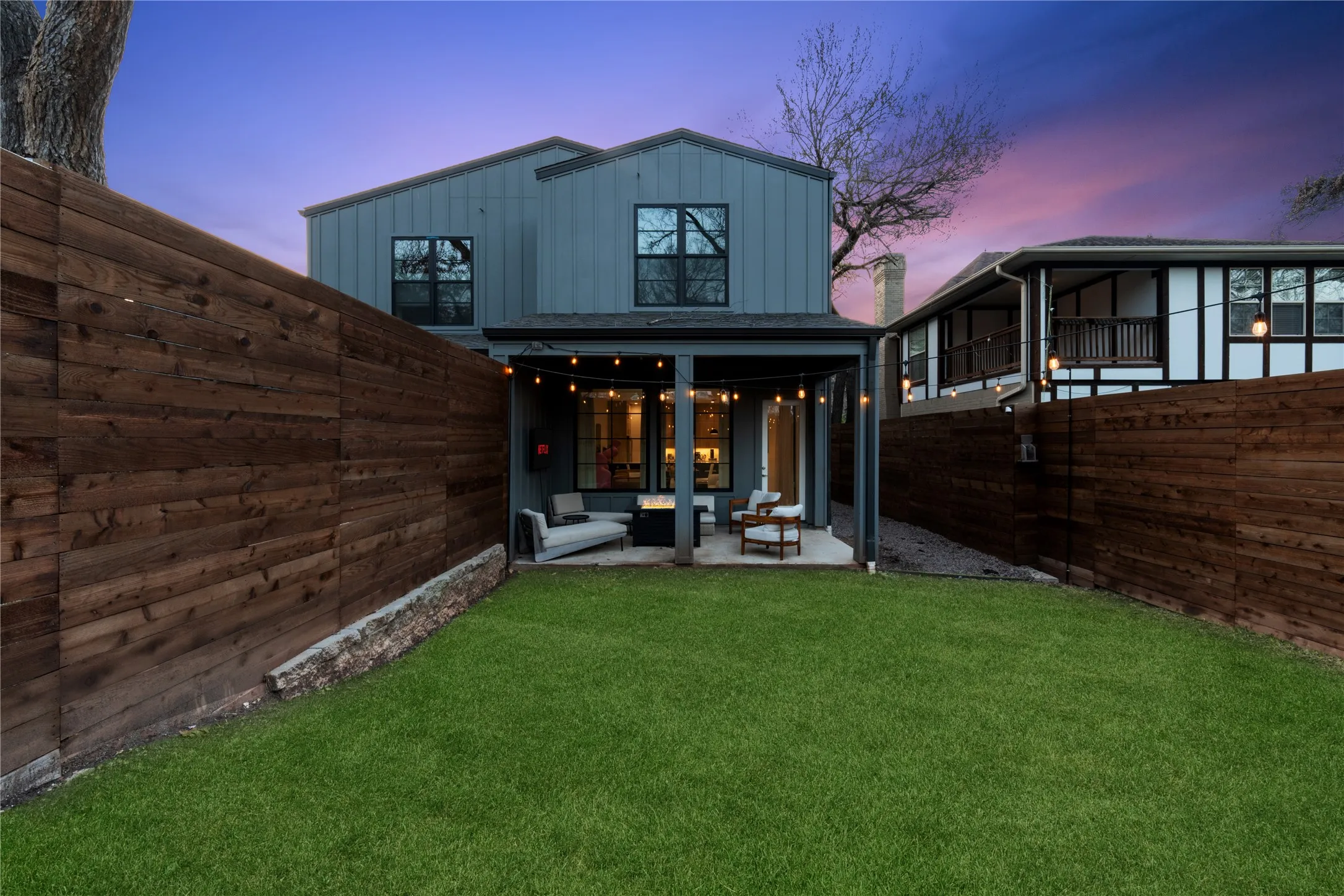 Private backyard featuring a manicured lawn and a wooden privacy fence