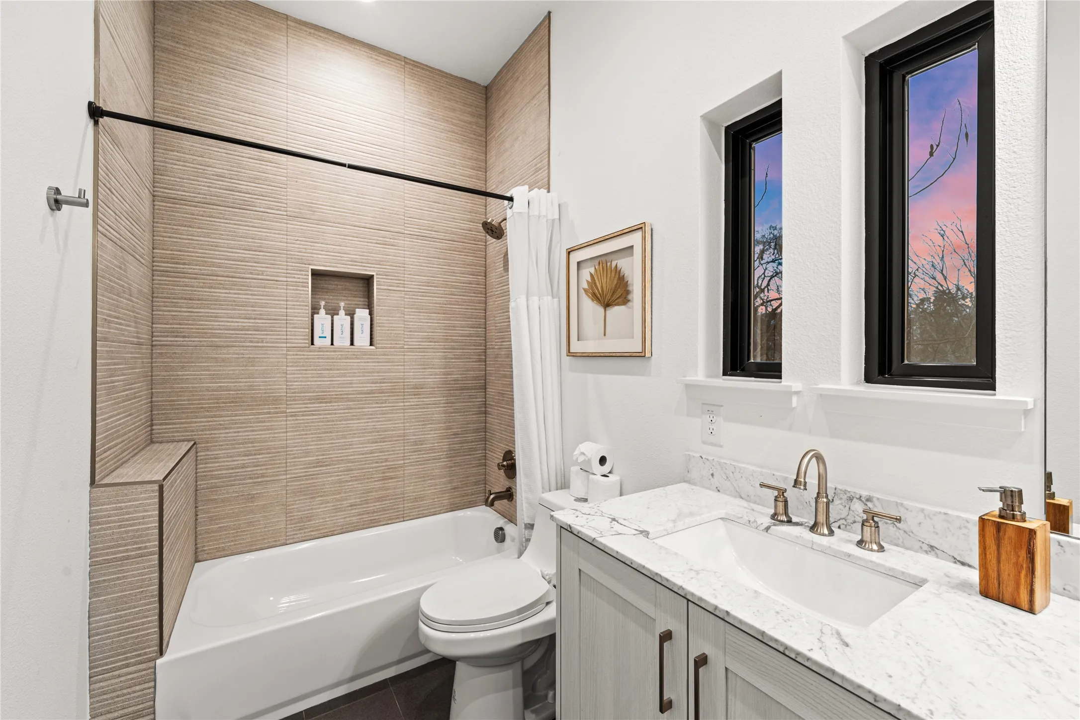 Bathtub with textured tile surround, recessed niche, and integrated bench