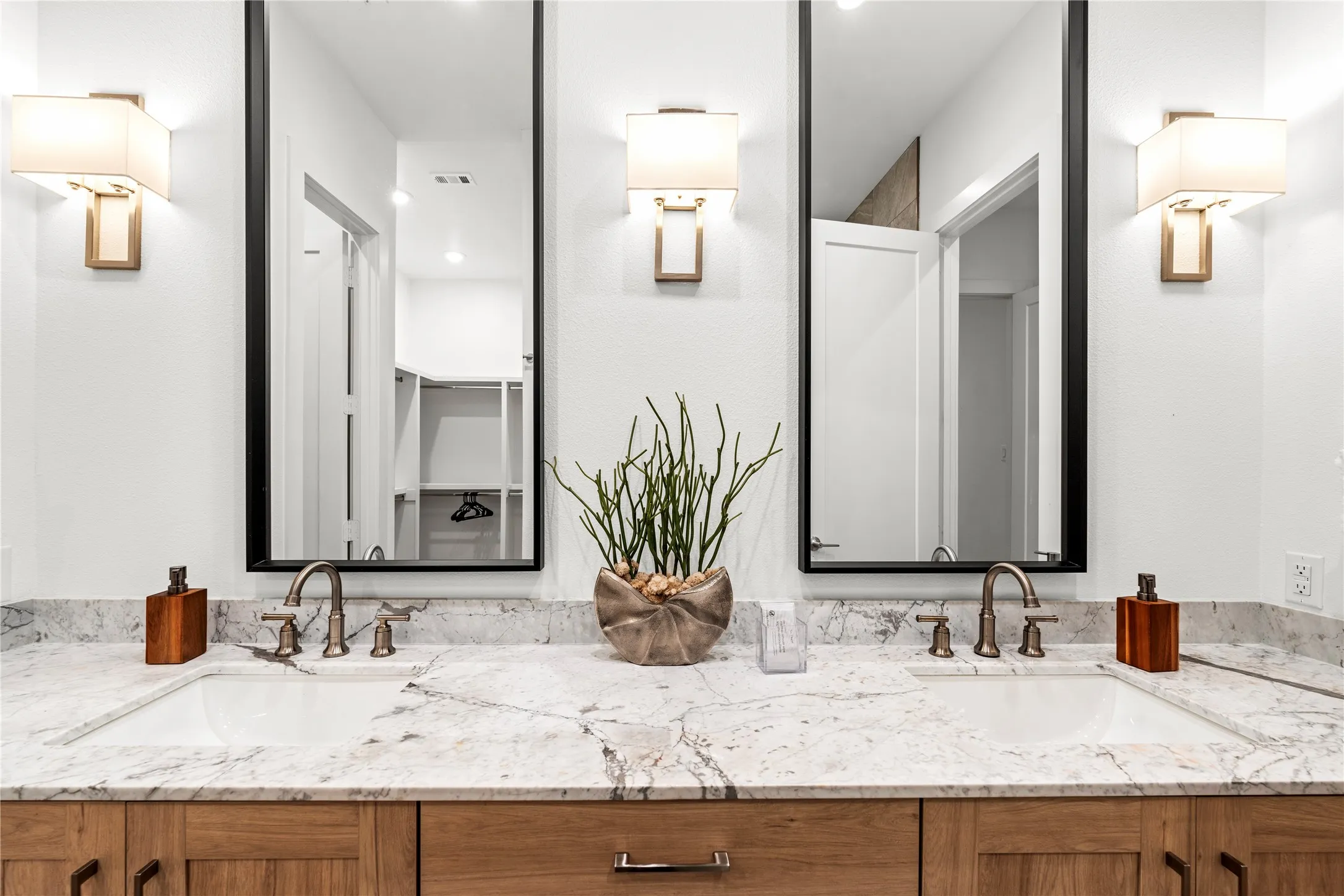 Primary bathroom with elegant light fixtures and spa accents.