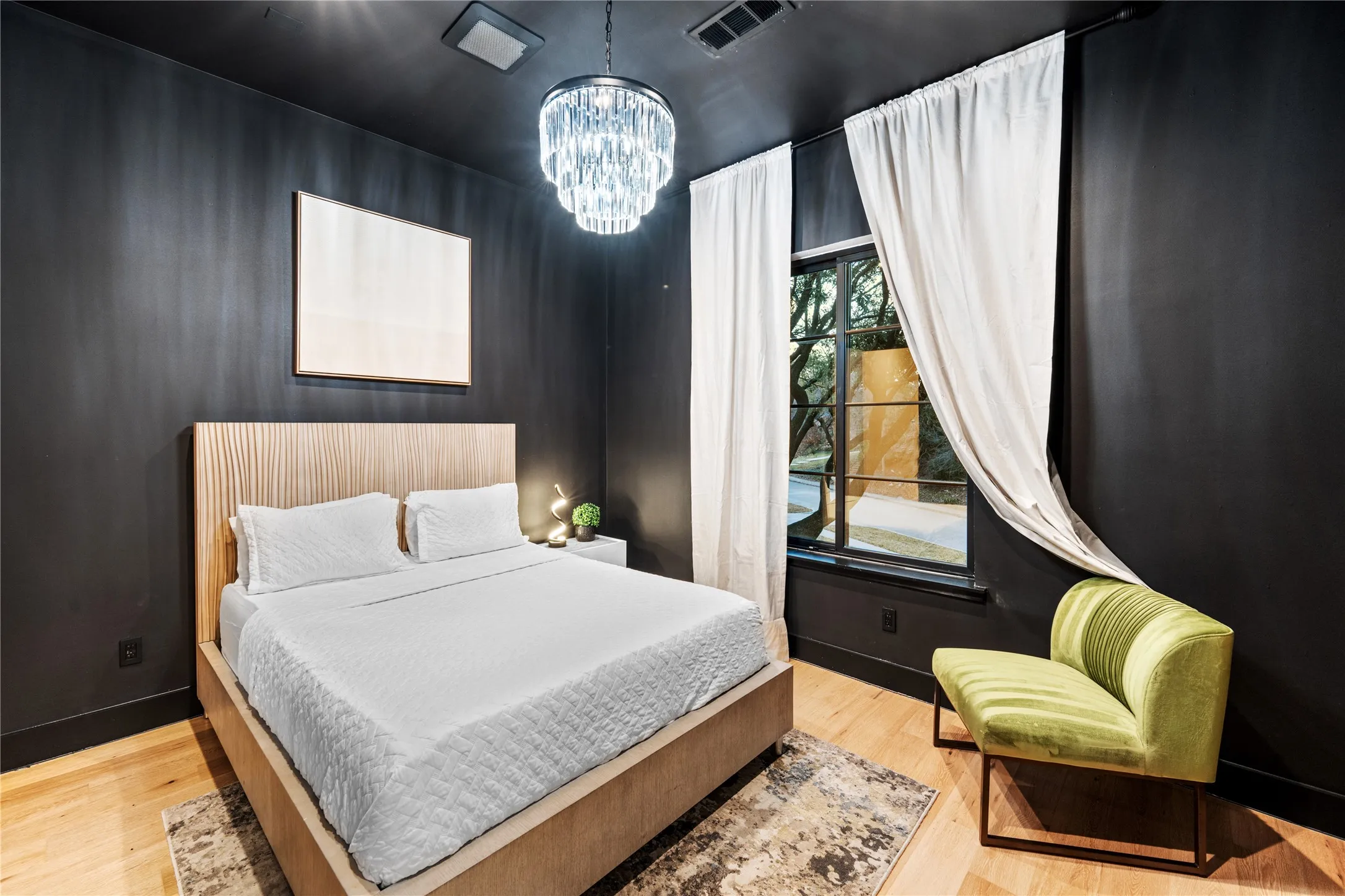Hardwood flooring, crystal chandelier, and a large window with black trim