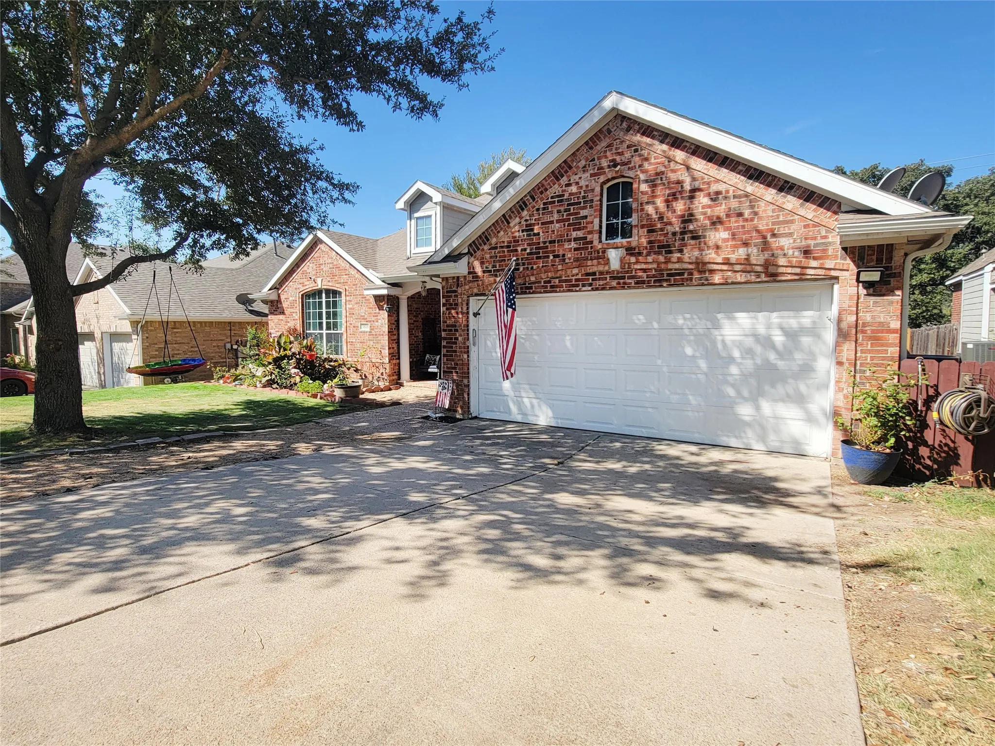 Brick facade, two-car garage, dormer window, arched entry, concrete driveway