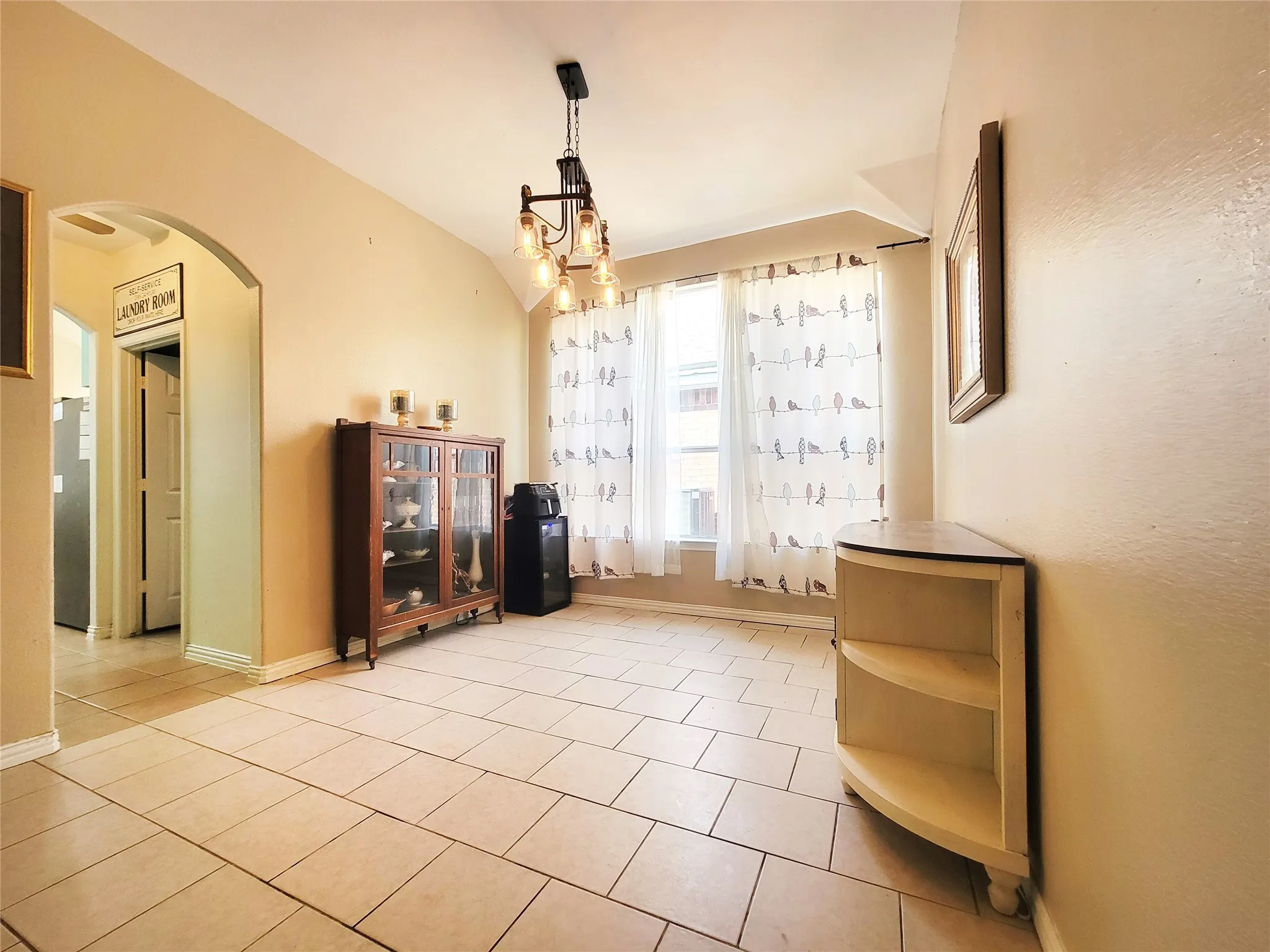 Tile flooring throughout, arched doorway, and a prominent window