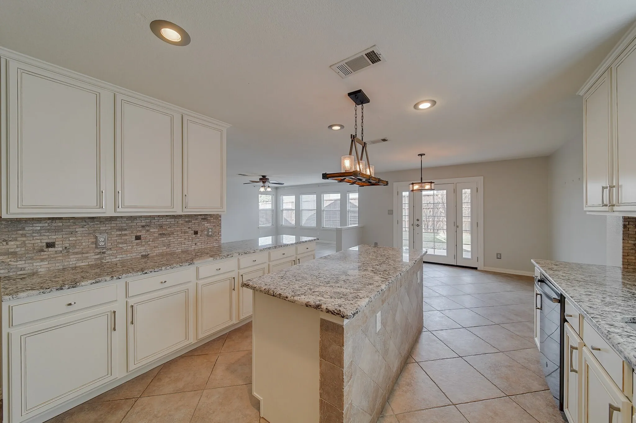 White cabinetry with brushed nickel hardware, granite countertops, tile backsplash, tile flooring, and glass-paneled double doors