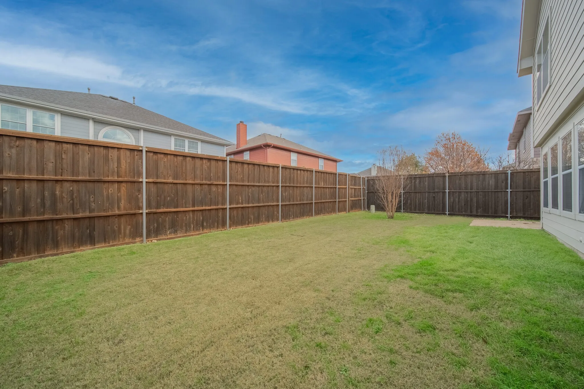 Fenced backyard featuring a lawn and a concrete patio