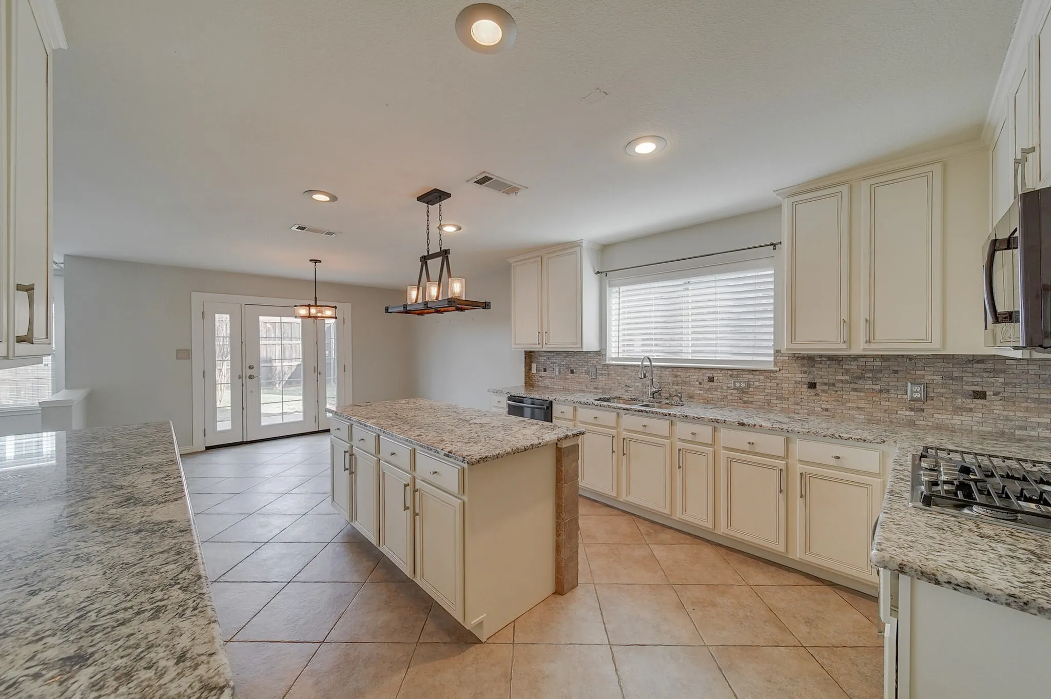 Kitchen featuring granite countertops, a tiled backsplash, recessed lighting, and a central island