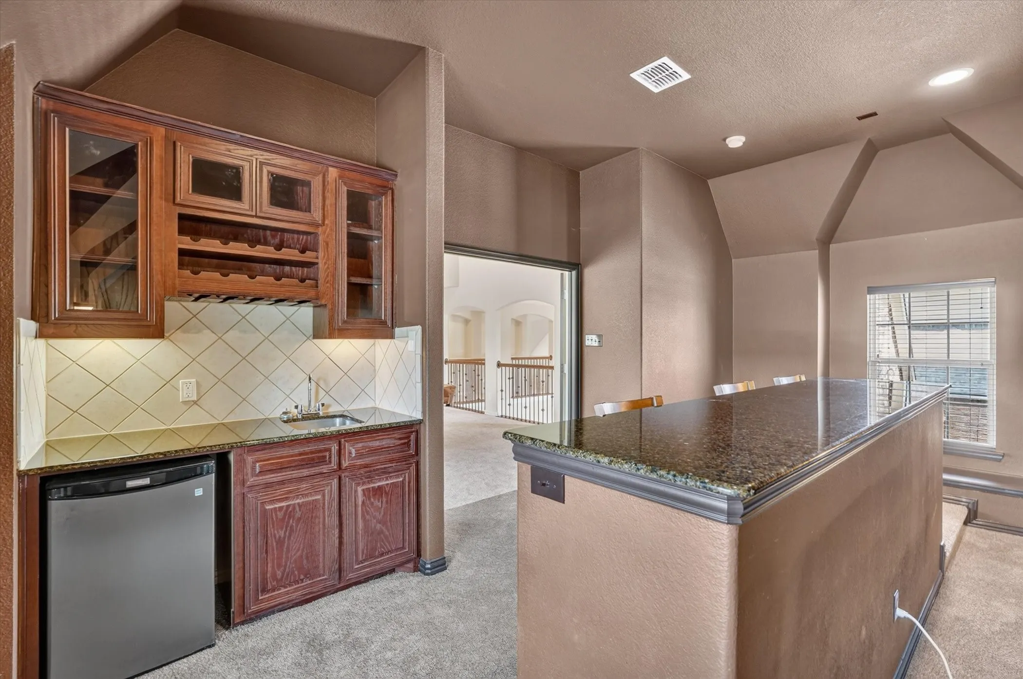 Make movie night legendary! This expansive, multi level media room has its own wet bar, beverage fridge and wine racks, plus a large granite serving space.