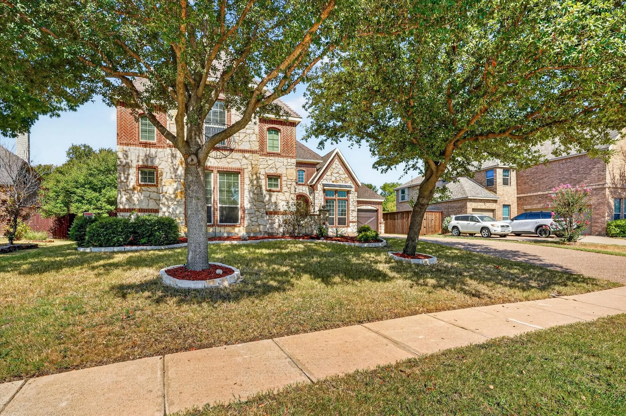 It sits framed by mature shade trees, and features a long driveway with 4 car garage for plenty of parking and storage.