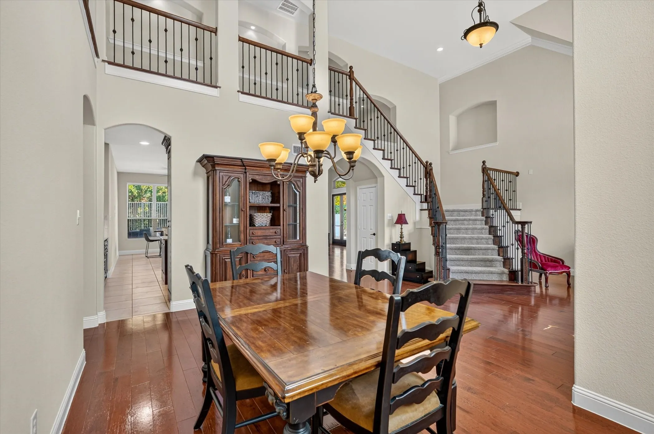 Grand formal dining room with soaring ceilings and beautiful hardwood flooring