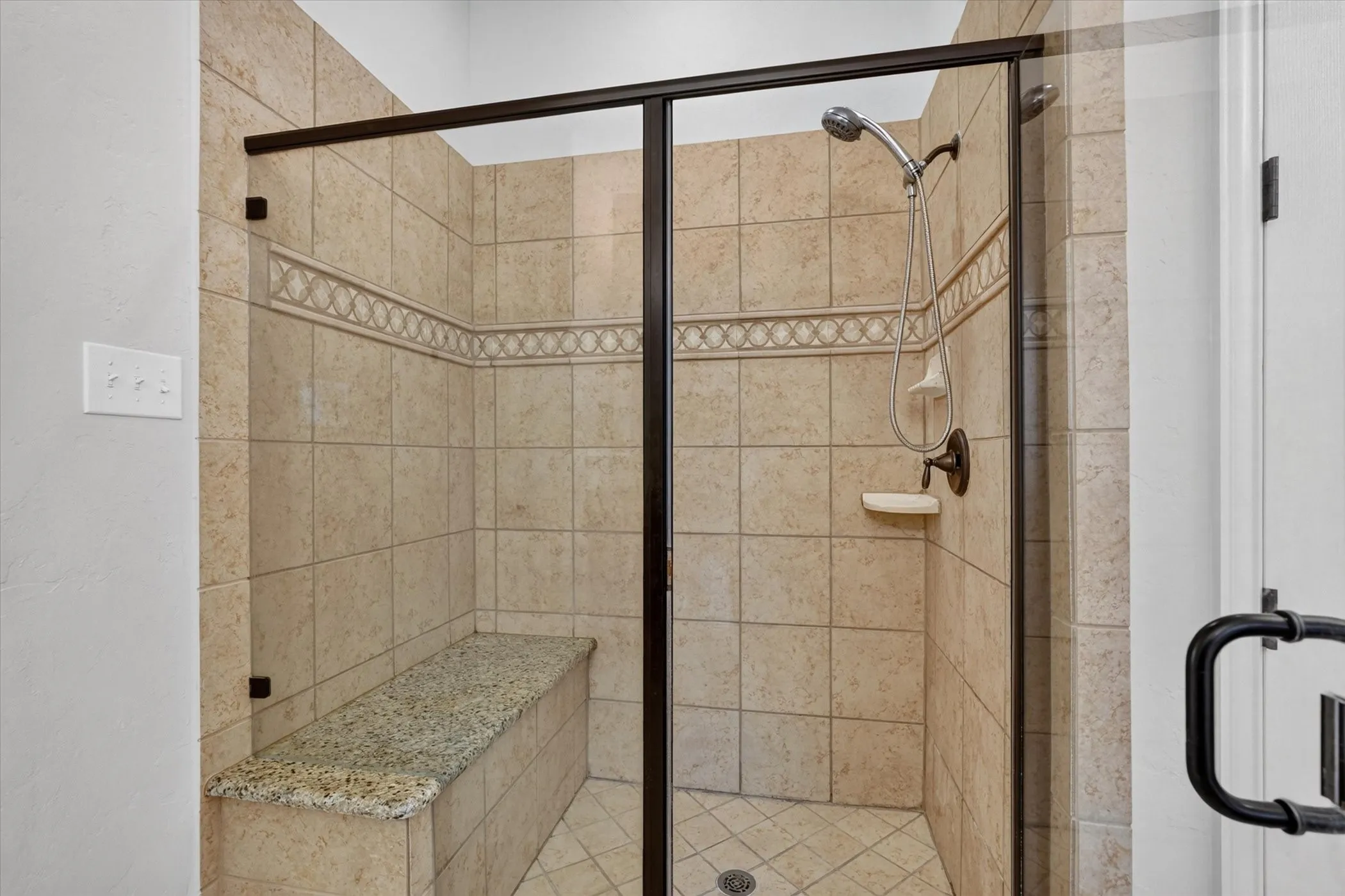The primary bath features an oversized shower with a granite seat.