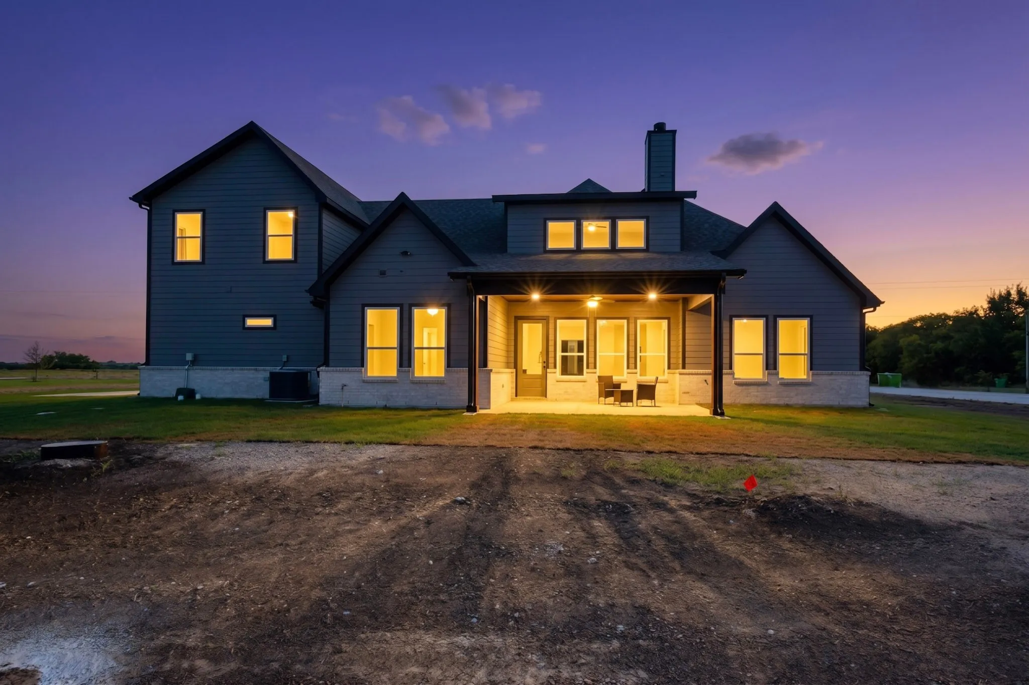 Two-story exterior with dark siding and a stone foundation