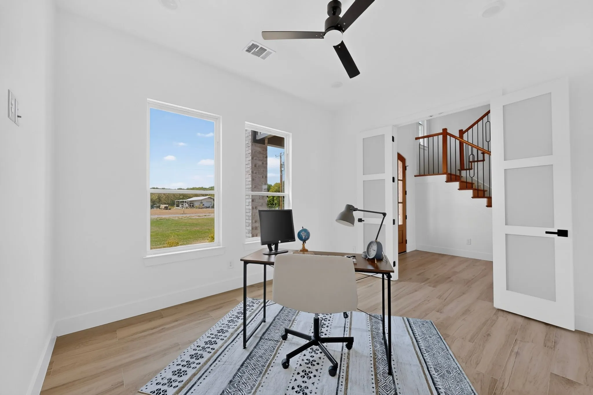 Recessed lighting, wood-finish flooring, ceiling fan, dual windows, and modern glass-paneled double doors
