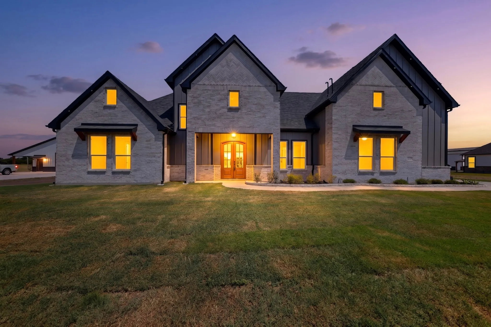 Contemporary exterior with light-colored brick, dark trim, and gabled rooflines