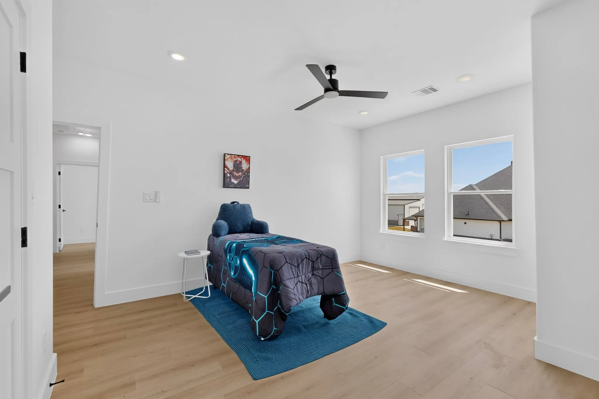 Bright room with two windows, light wood-finish flooring, recessed lighting, and a ceiling fan