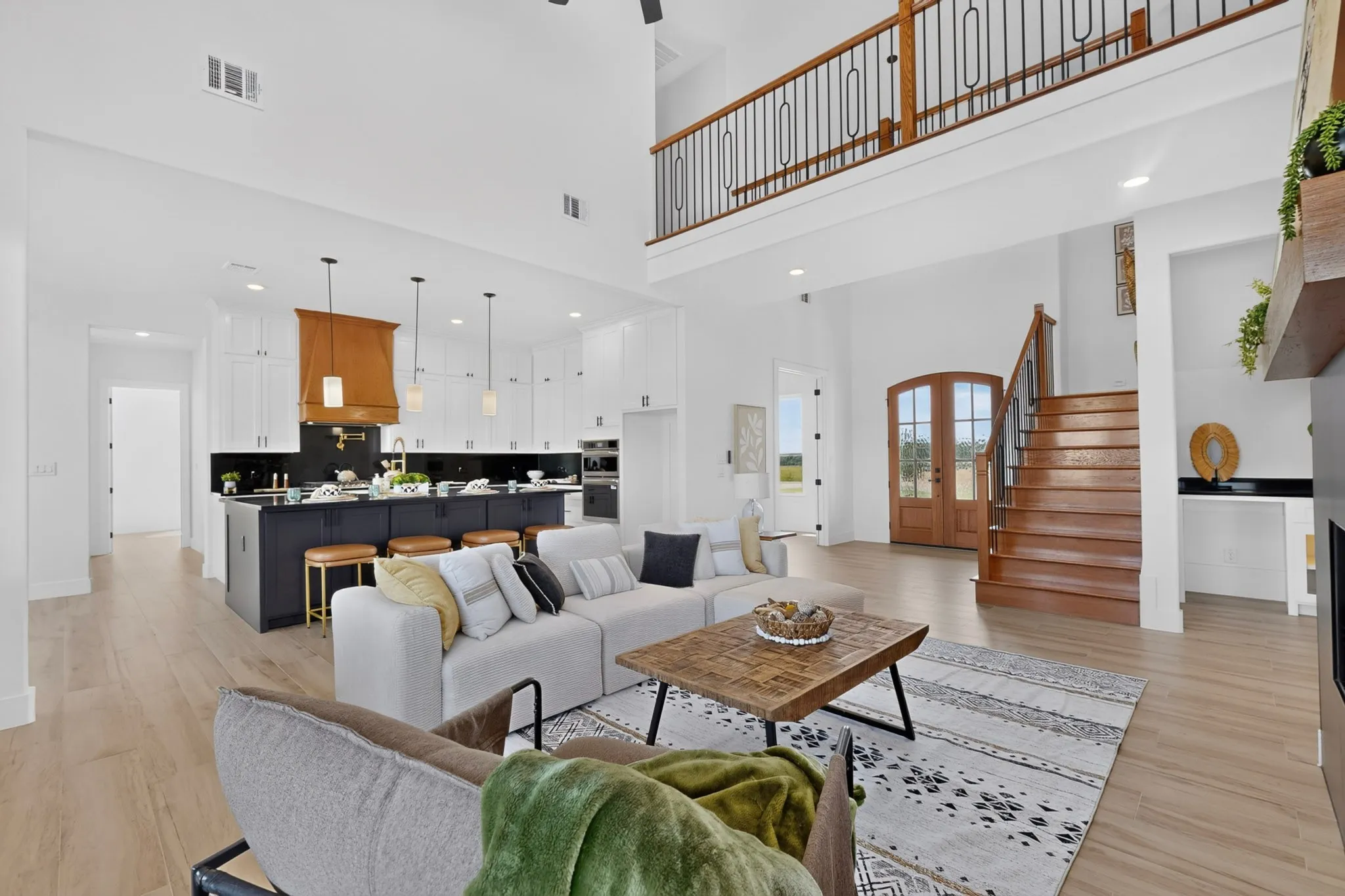 Open-concept living space featuring high ceilings and light wood-finish flooring