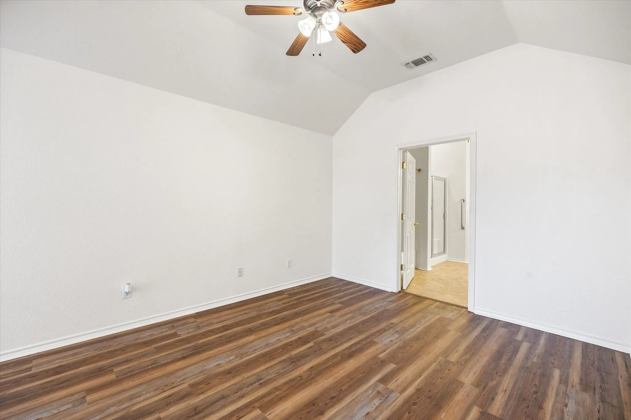 Primary bedroom with luxury vinyl plank flooring, ceiling fan and ensuite bathroom