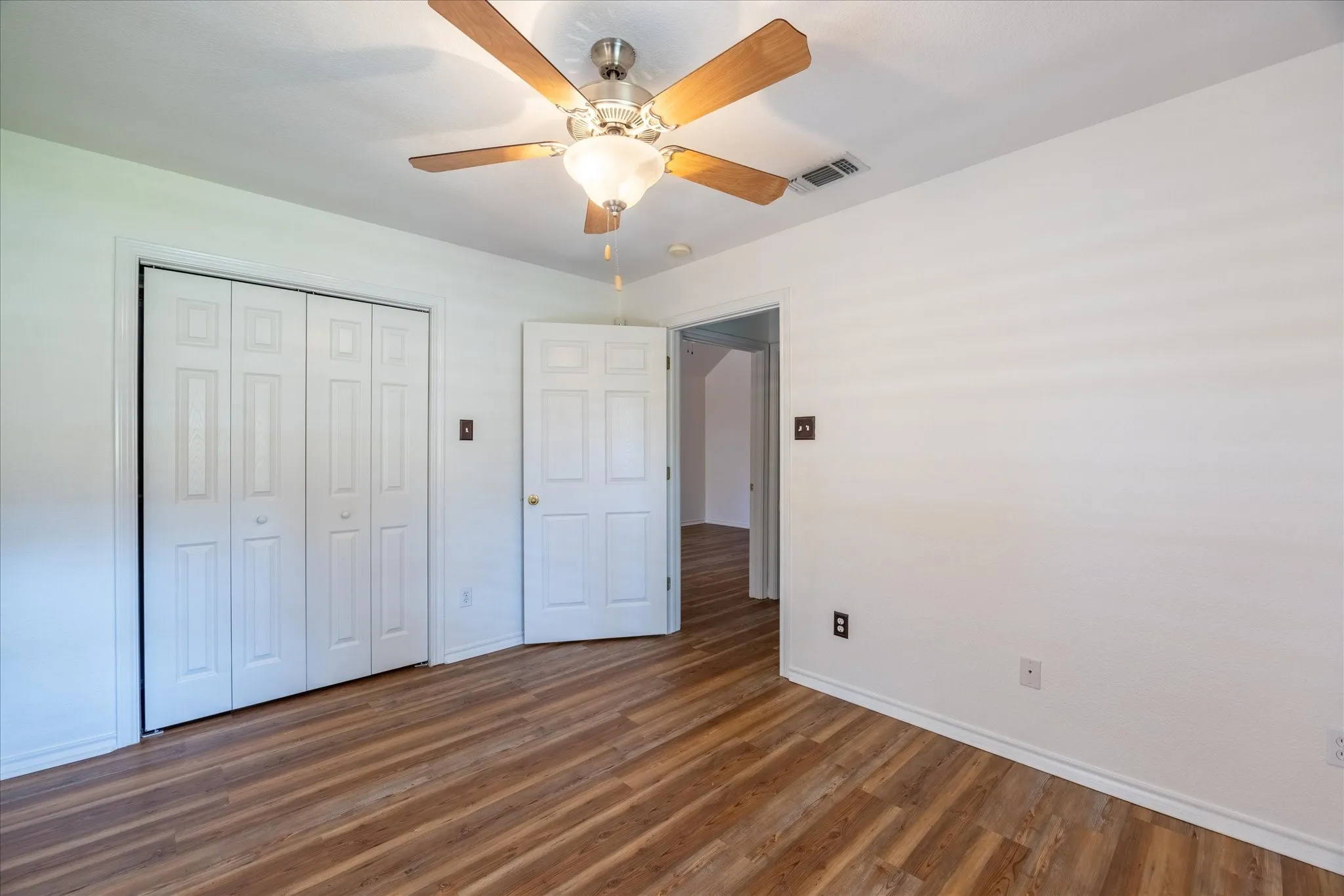 2nd bedroom with LVP flooring, ceiling fan with integrated lighting, and closet