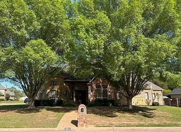 Brick exterior with a prominent arched entry and a stone mailbox