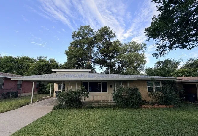 Single-story residence featuring a carport, a gabled roof, and a concrete driveway