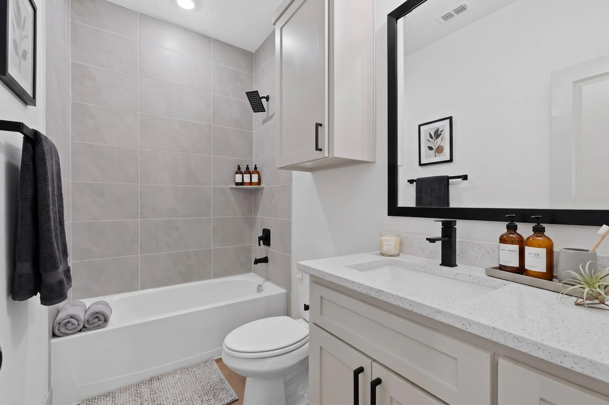 (Virtual Staging)Full bathroom featuring a rectangular bathtub, tiled shower surround, recessed lighting, a single vanity with a solid surface countertop, and matte black fixtures