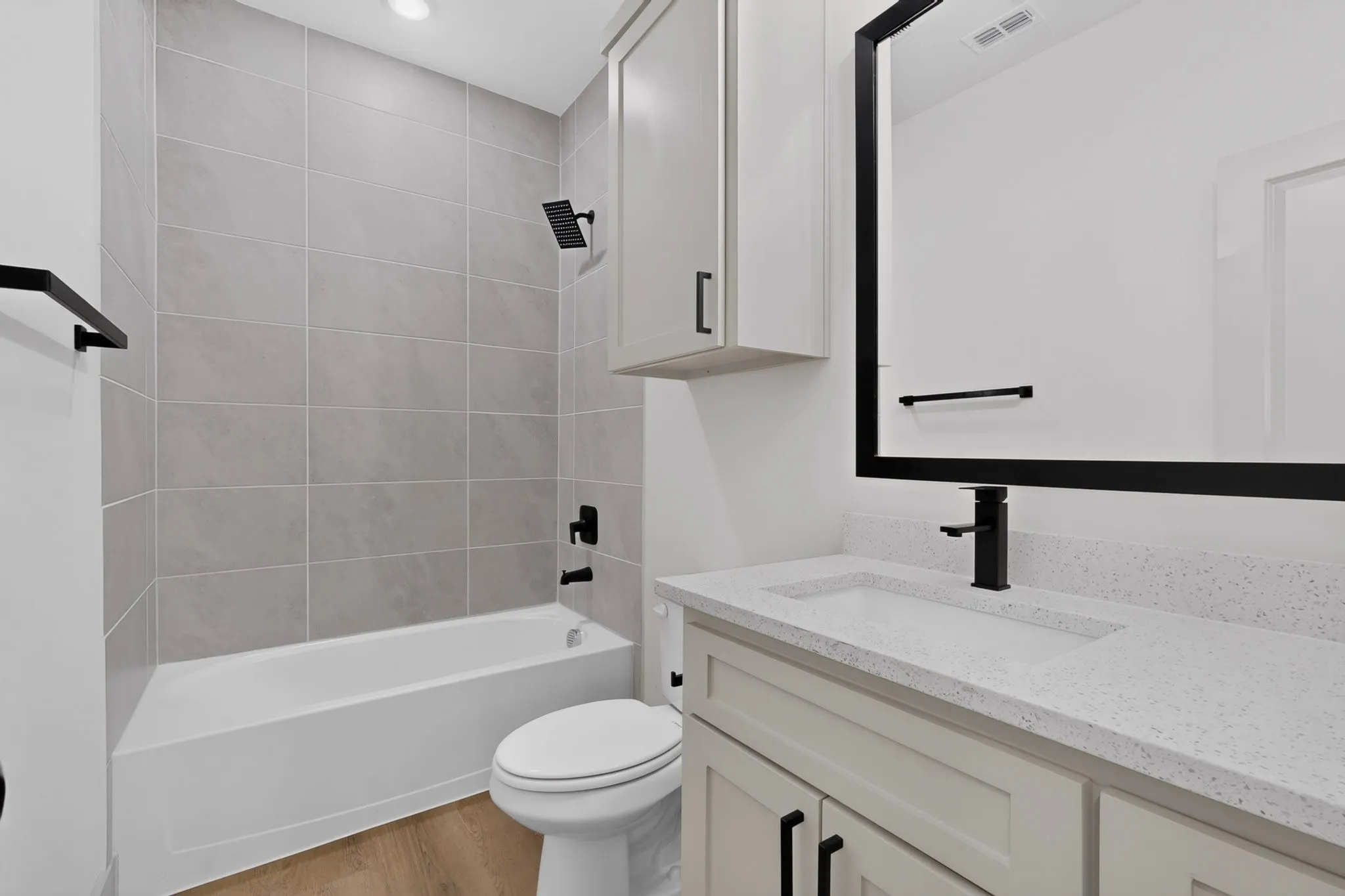 Bathroom featuring a white vanity with a white countertop, built-in sink, and black faucet