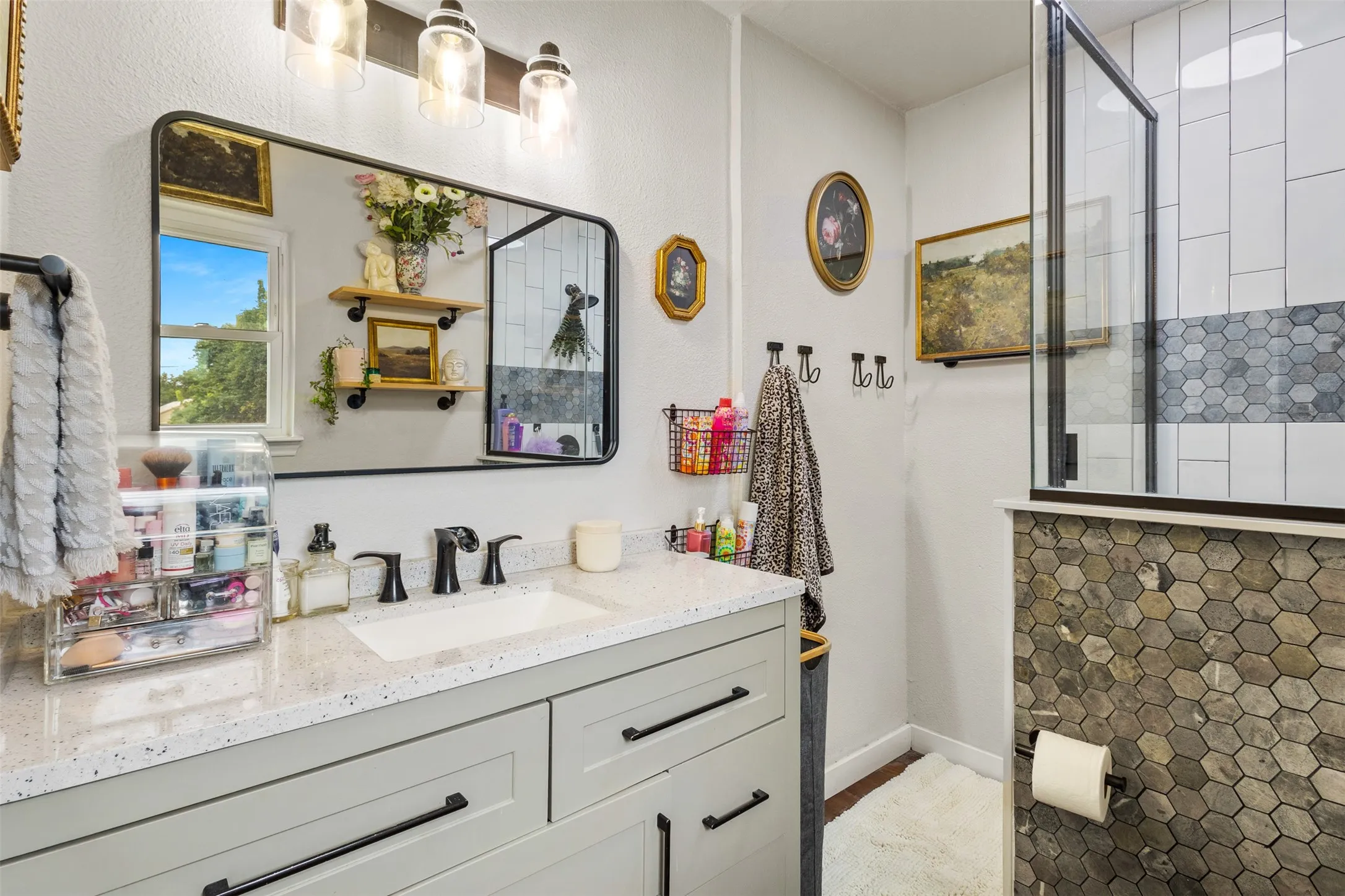 Vanity with a speckled countertop, undermount sink, and matte black faucet