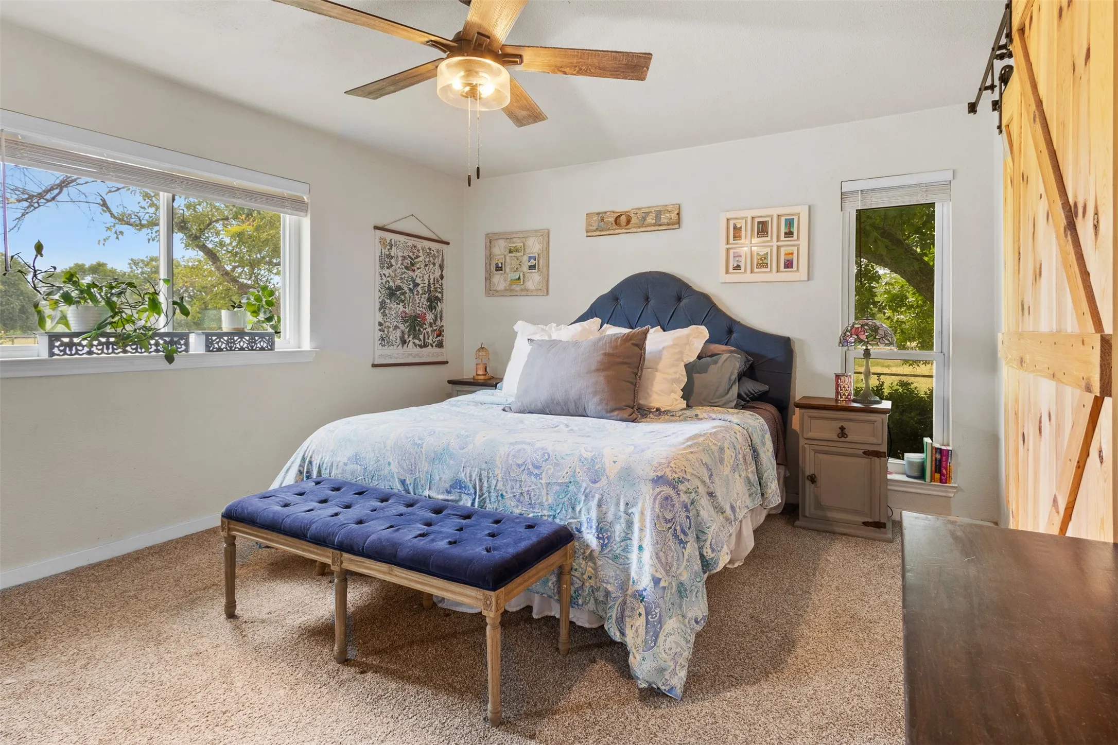 Recessed lighting, wood-finish ceiling fan, wood-finish barn door, carpet flooring, upholstered headboard