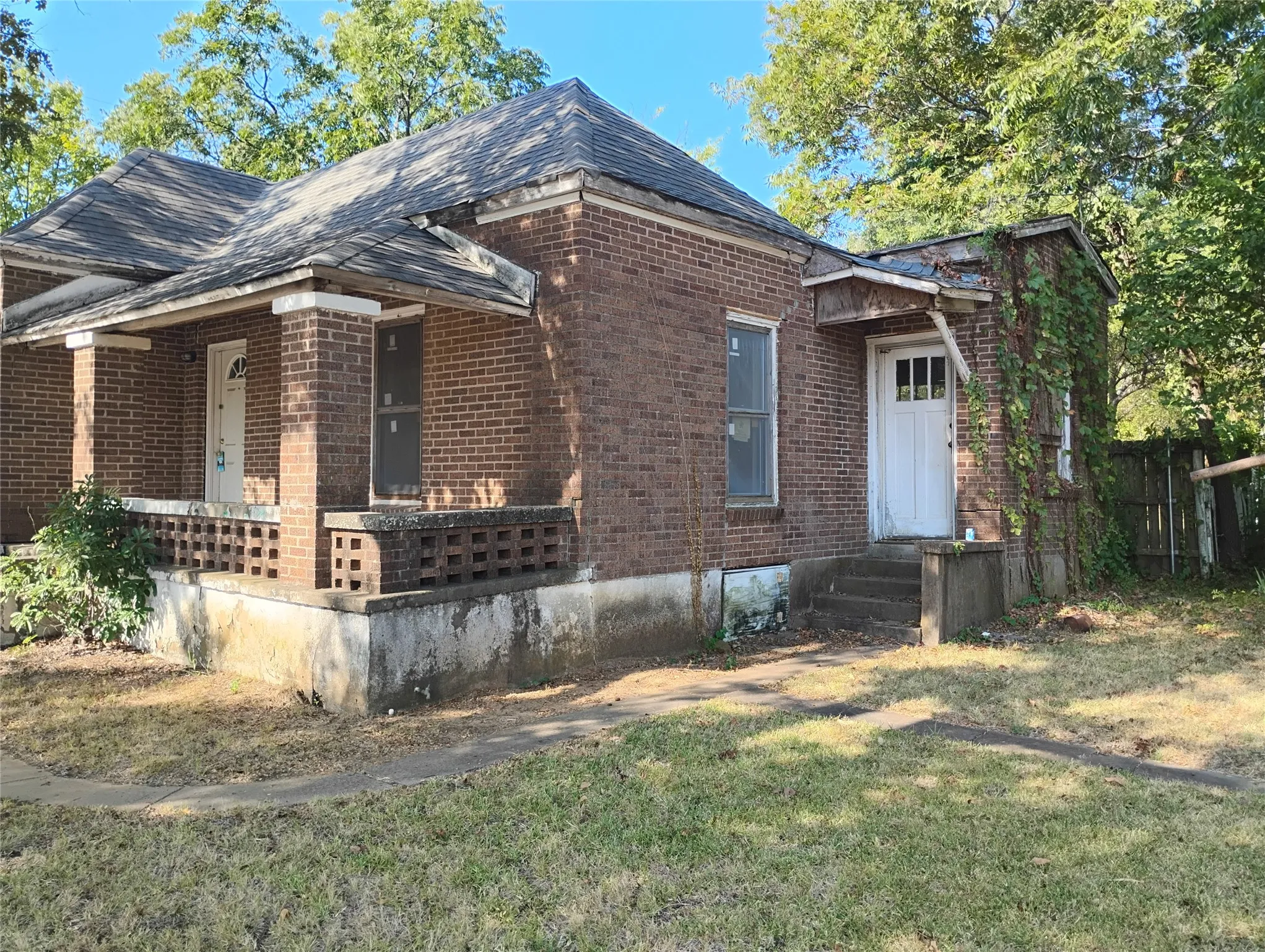 Brick exterior with covered front porch, brick columns, and a secondary entry with an awning