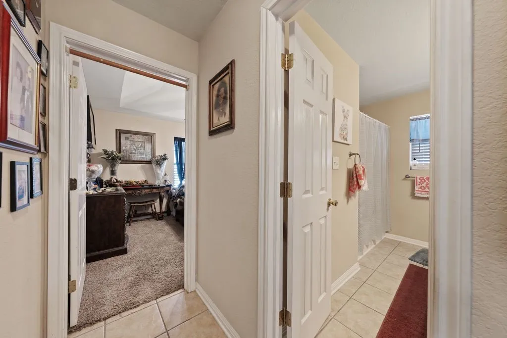 Hallway featuring neutral-toned walls and tile flooring