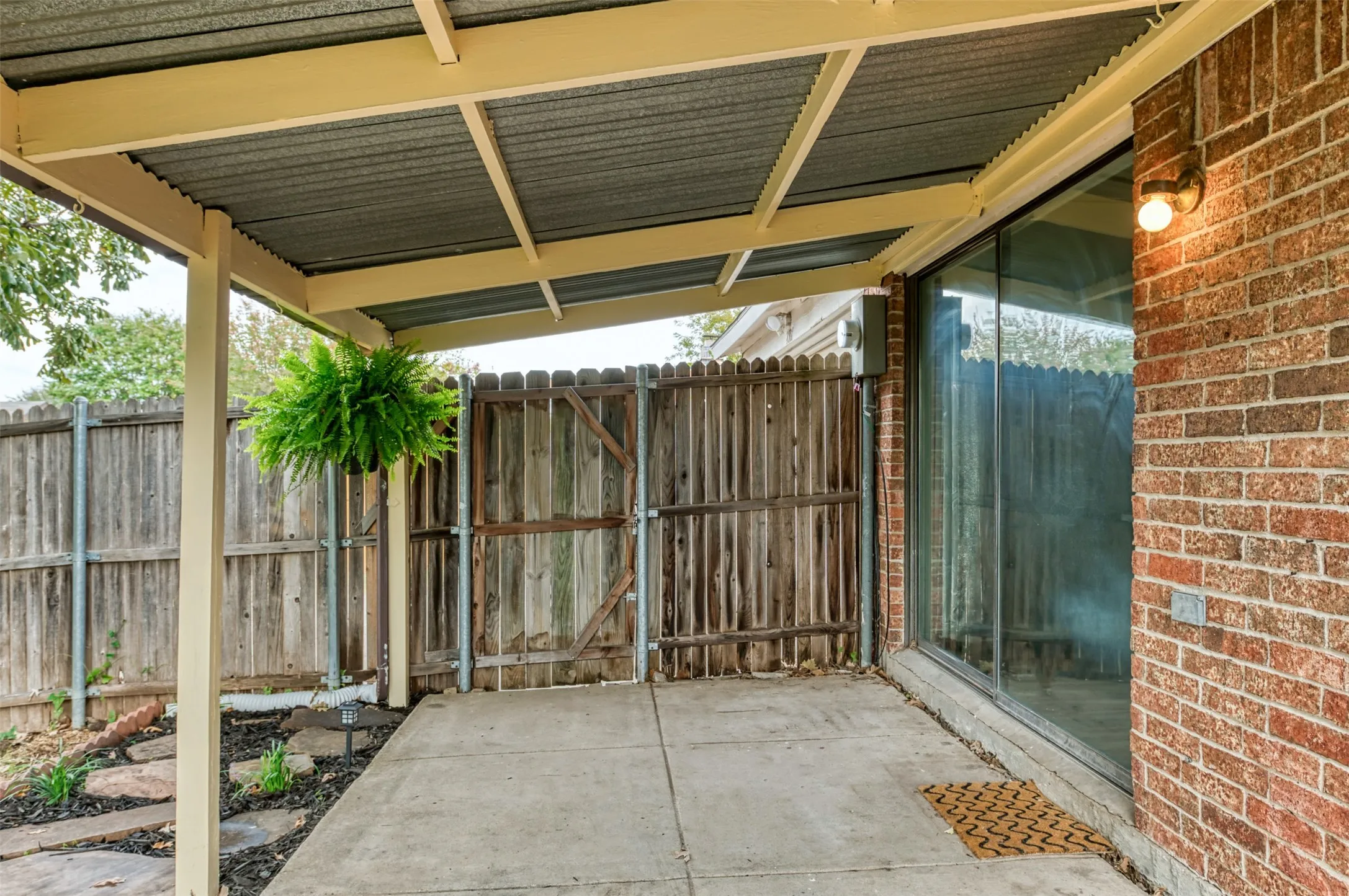 Covered patio with a corrugated metal roof and exposed wood beams