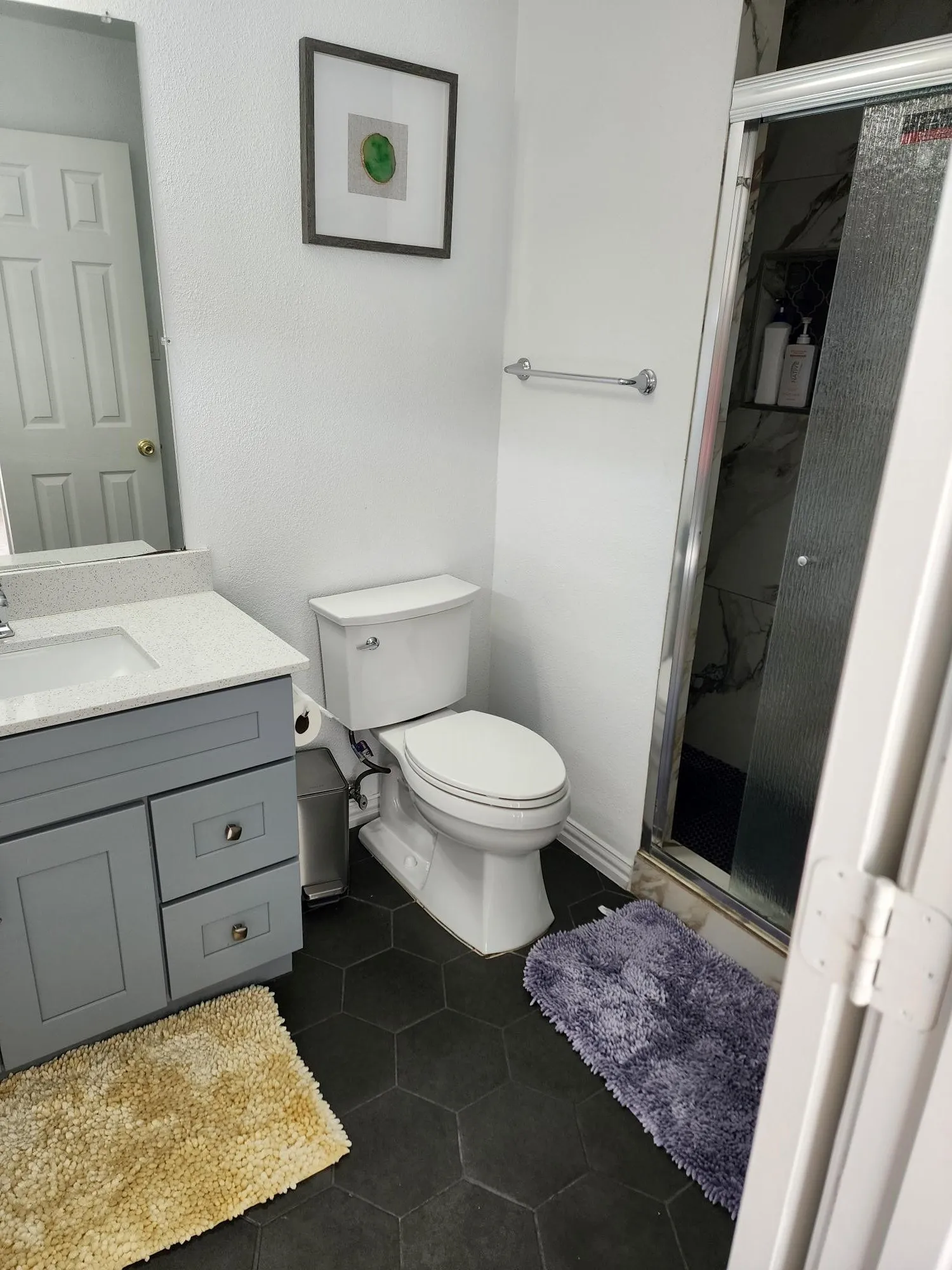 Hexagonal floor tiles complement the vanity with a light-toned countertop