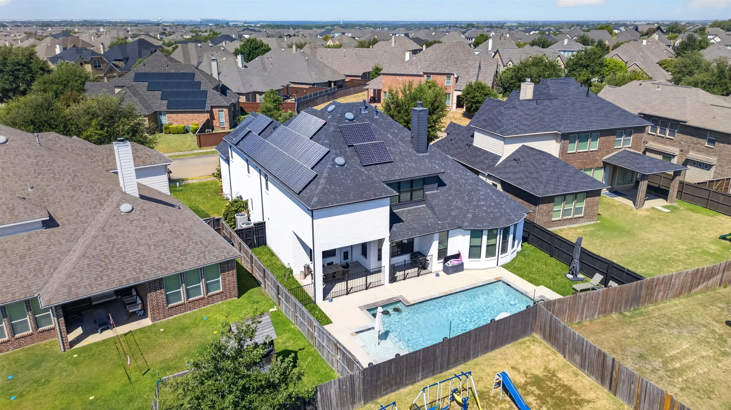 White exterior with a dark shingle roof featuring multiple solar panels