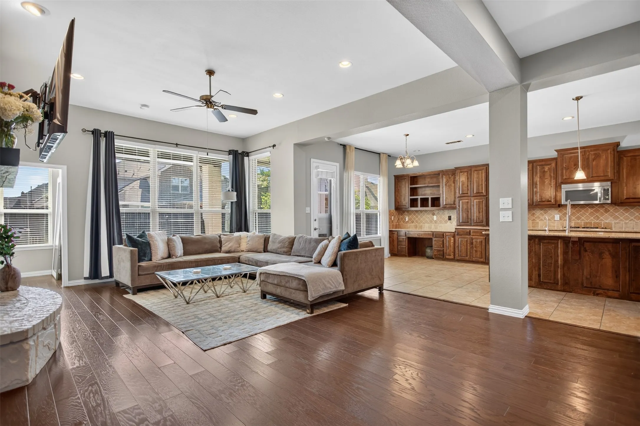Open-concept living space featuring wood-finish flooring, recessed lighting, and a ceiling fan