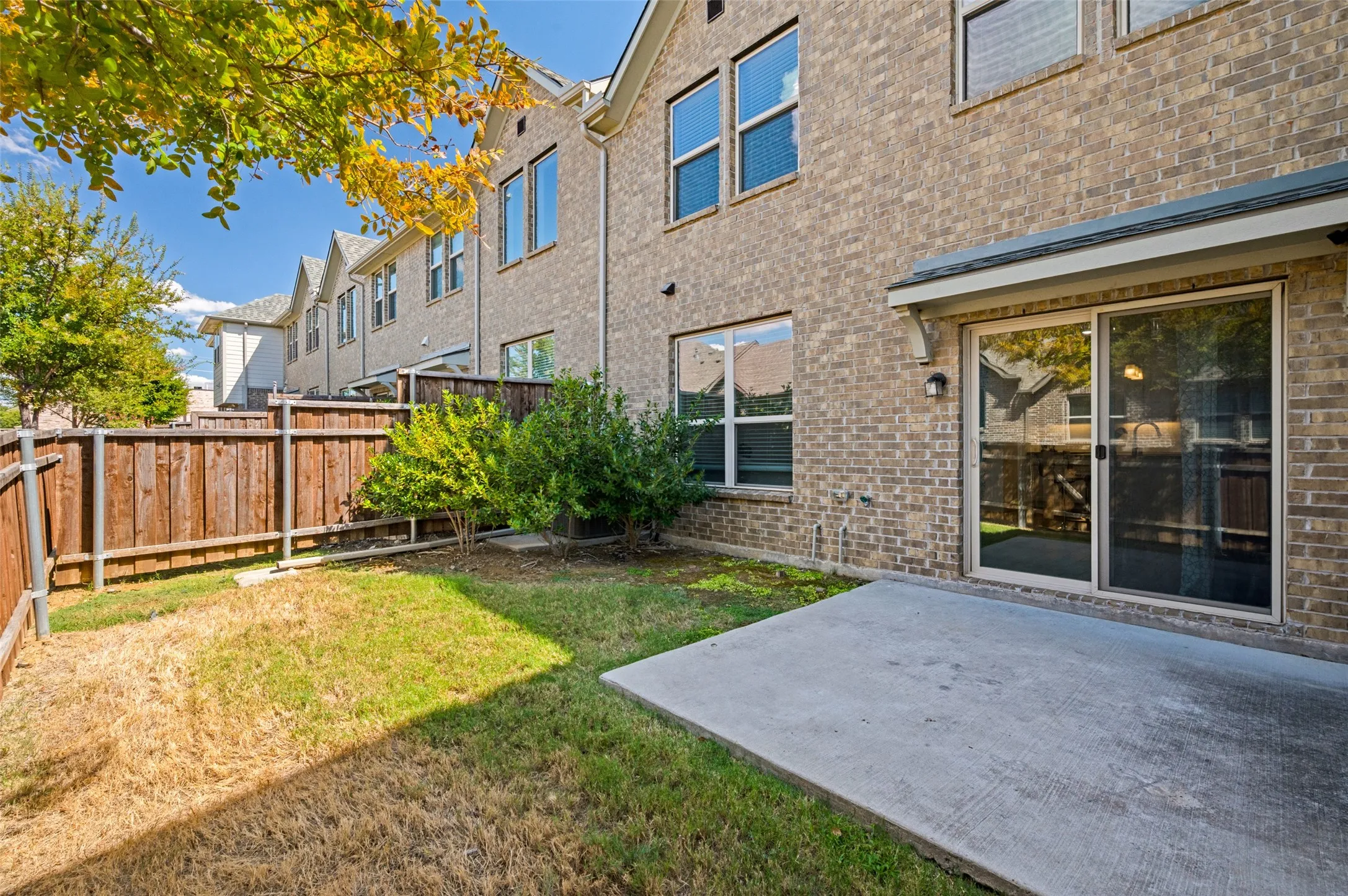 Backyard with patio, and shade tree.