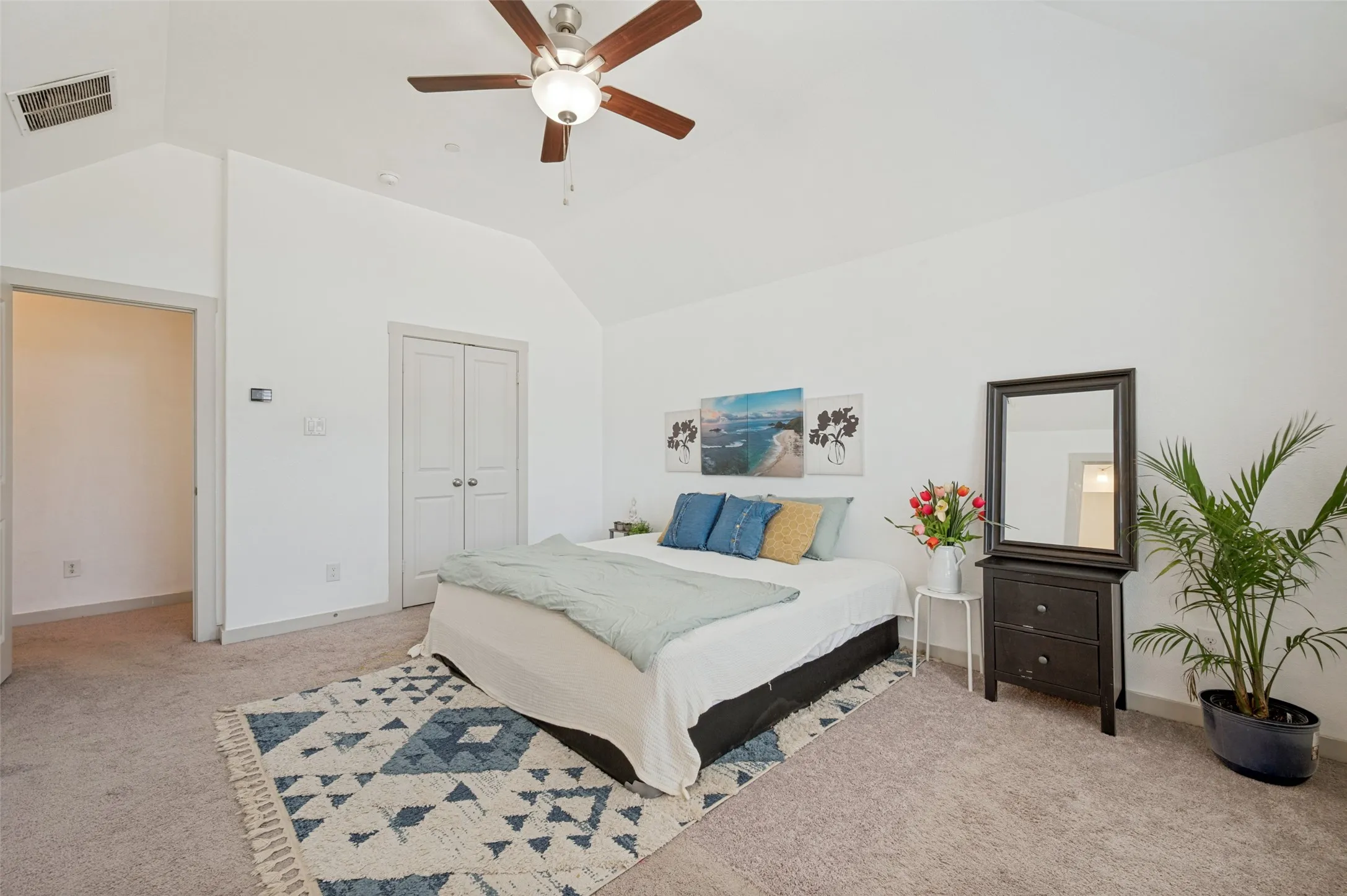 
spacious primary bedroom with walk in closet and ceiling fan.