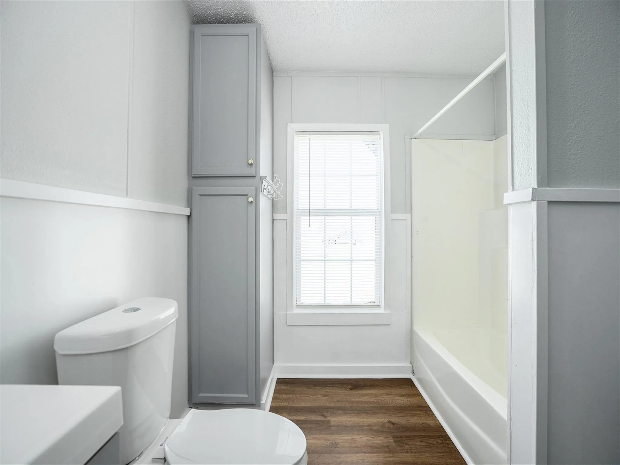 Full bathroom with shower / tub combination, a textured ceiling, dark wood finished floors, and vanity